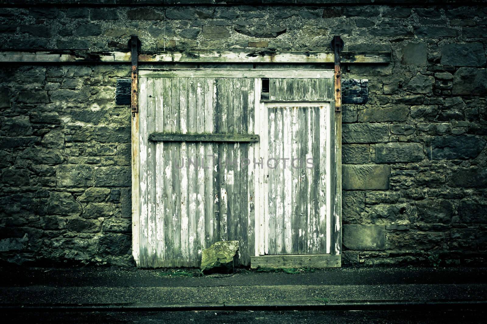 Old weathered wooden door in a wall in muted tones