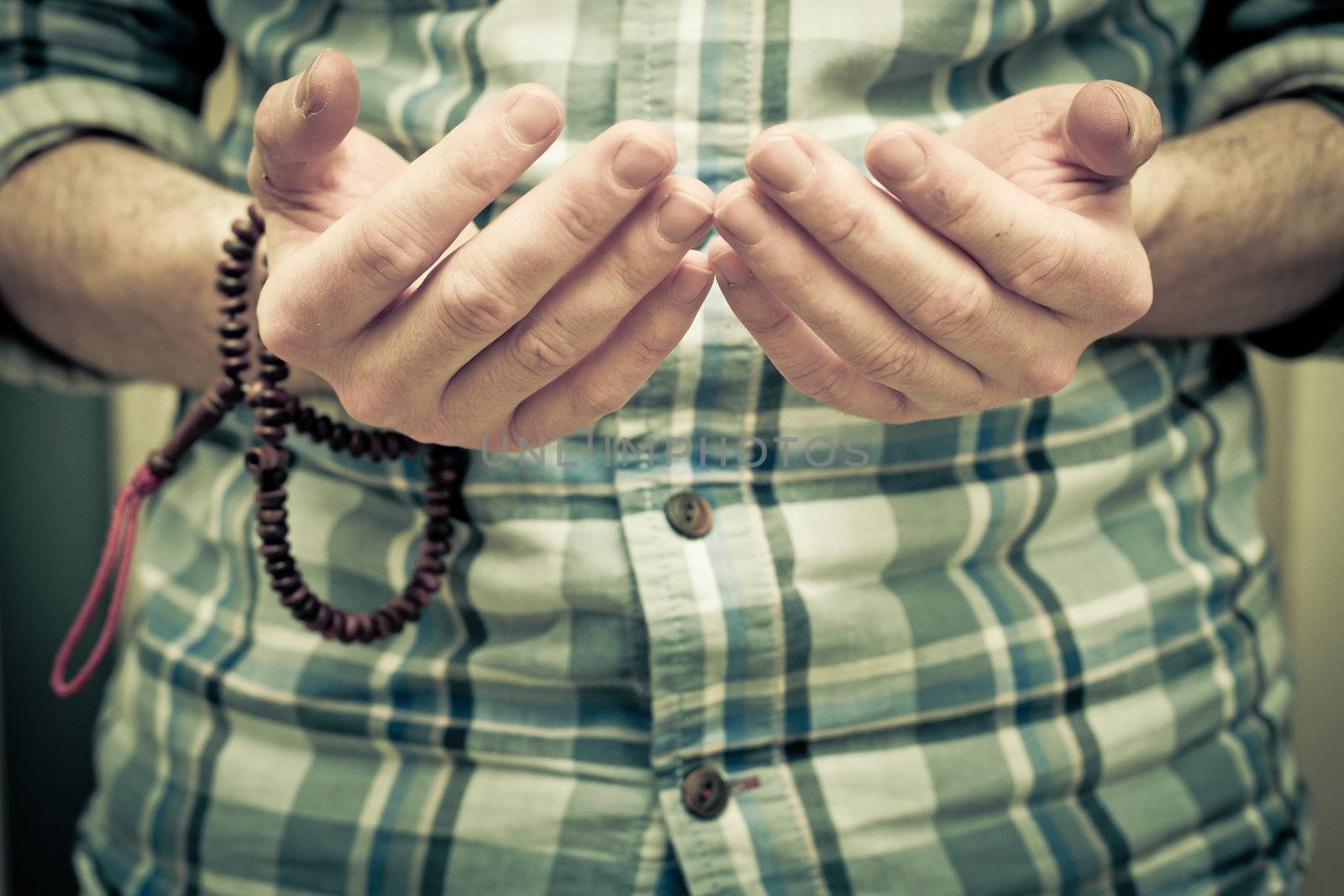 Hands of a young muslim man praying