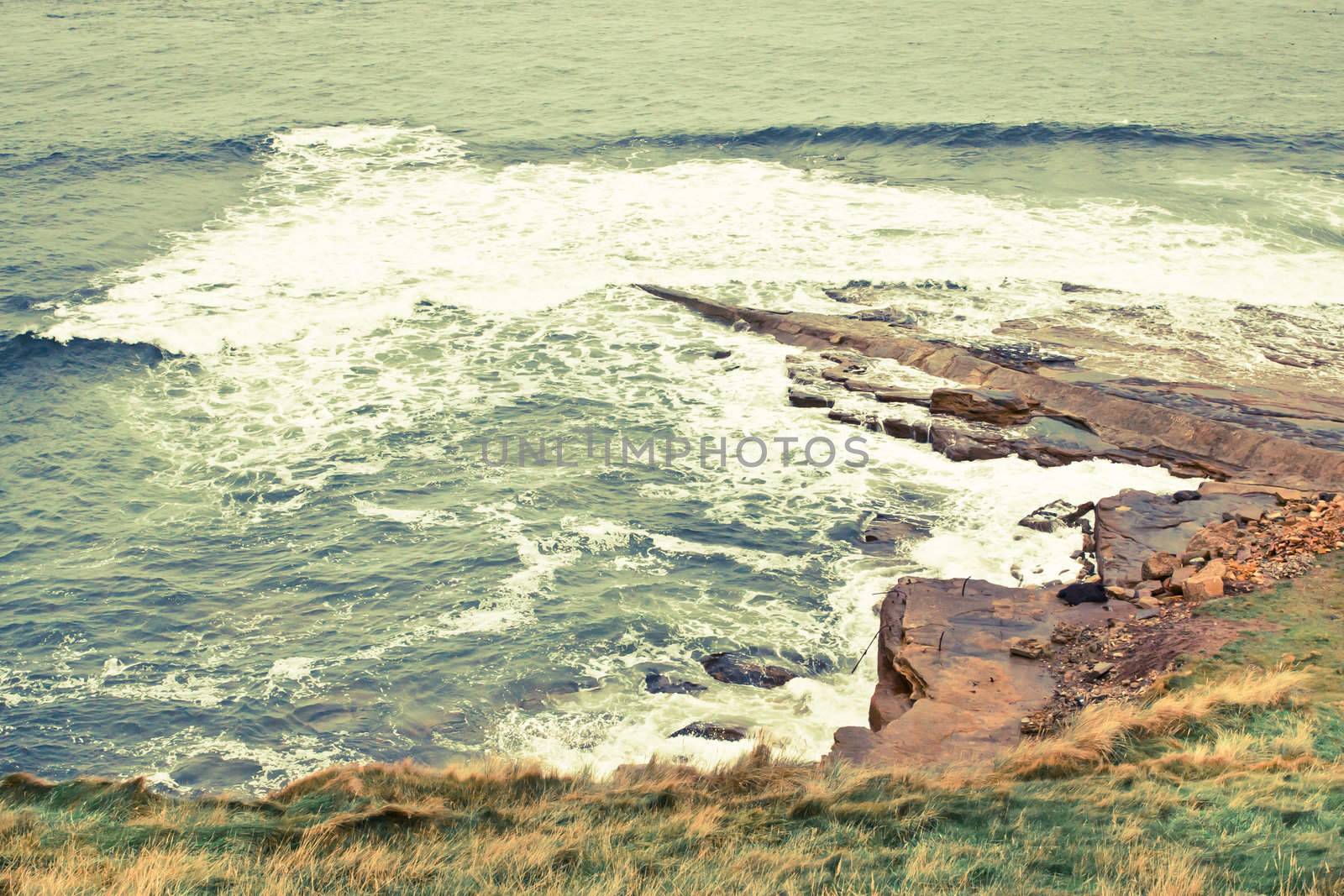 Rough sea crashing against coastal rocks in Scotland