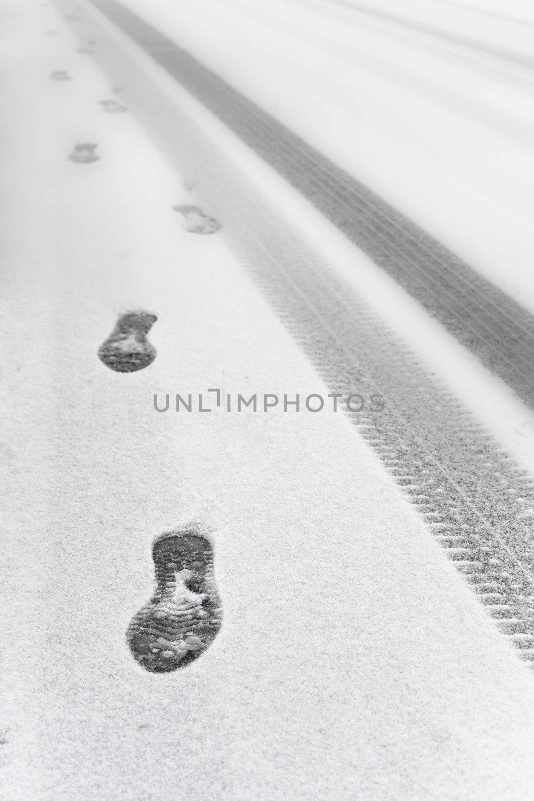 Footprints and tyre tracks in the snow