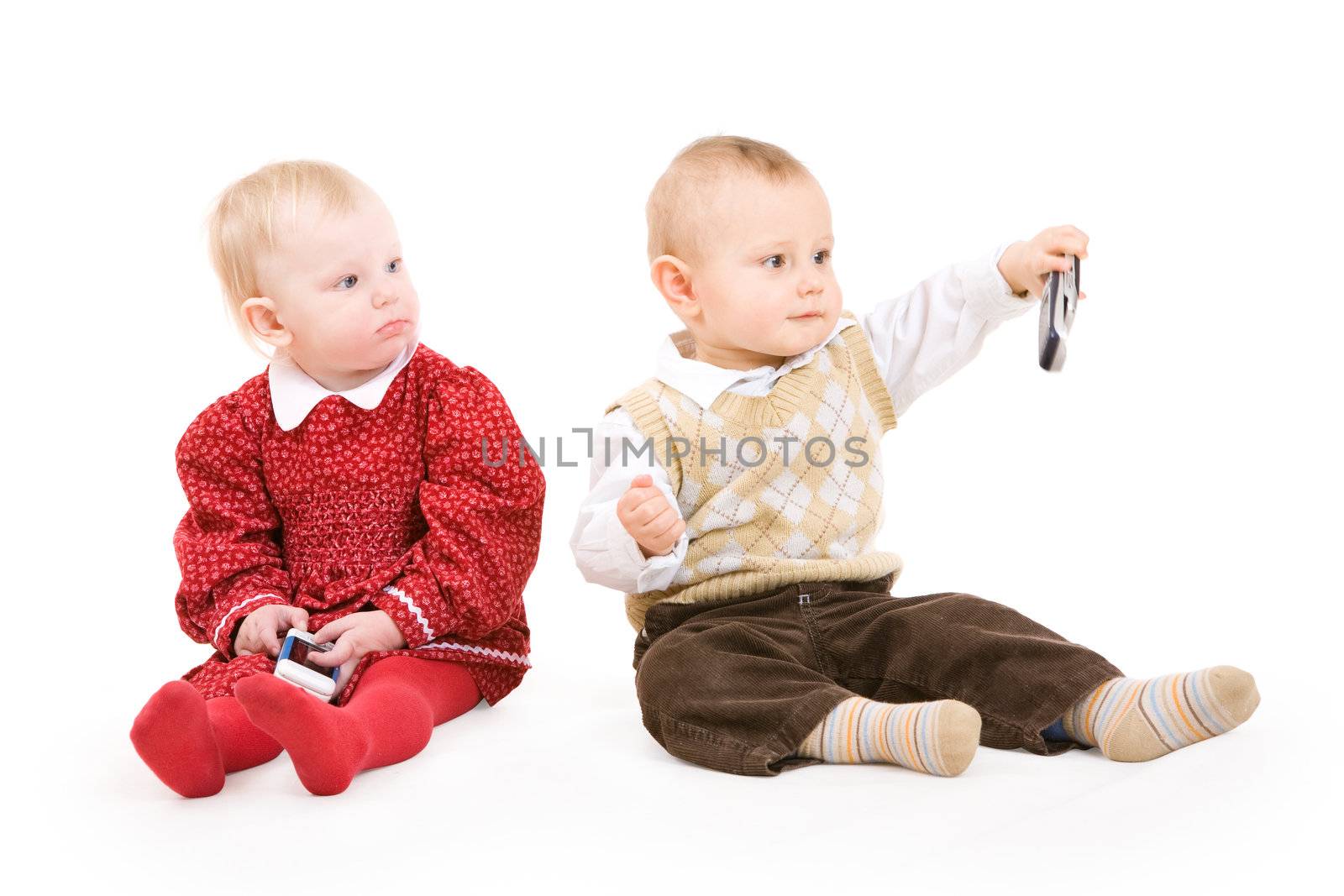 two children on the floor with phones