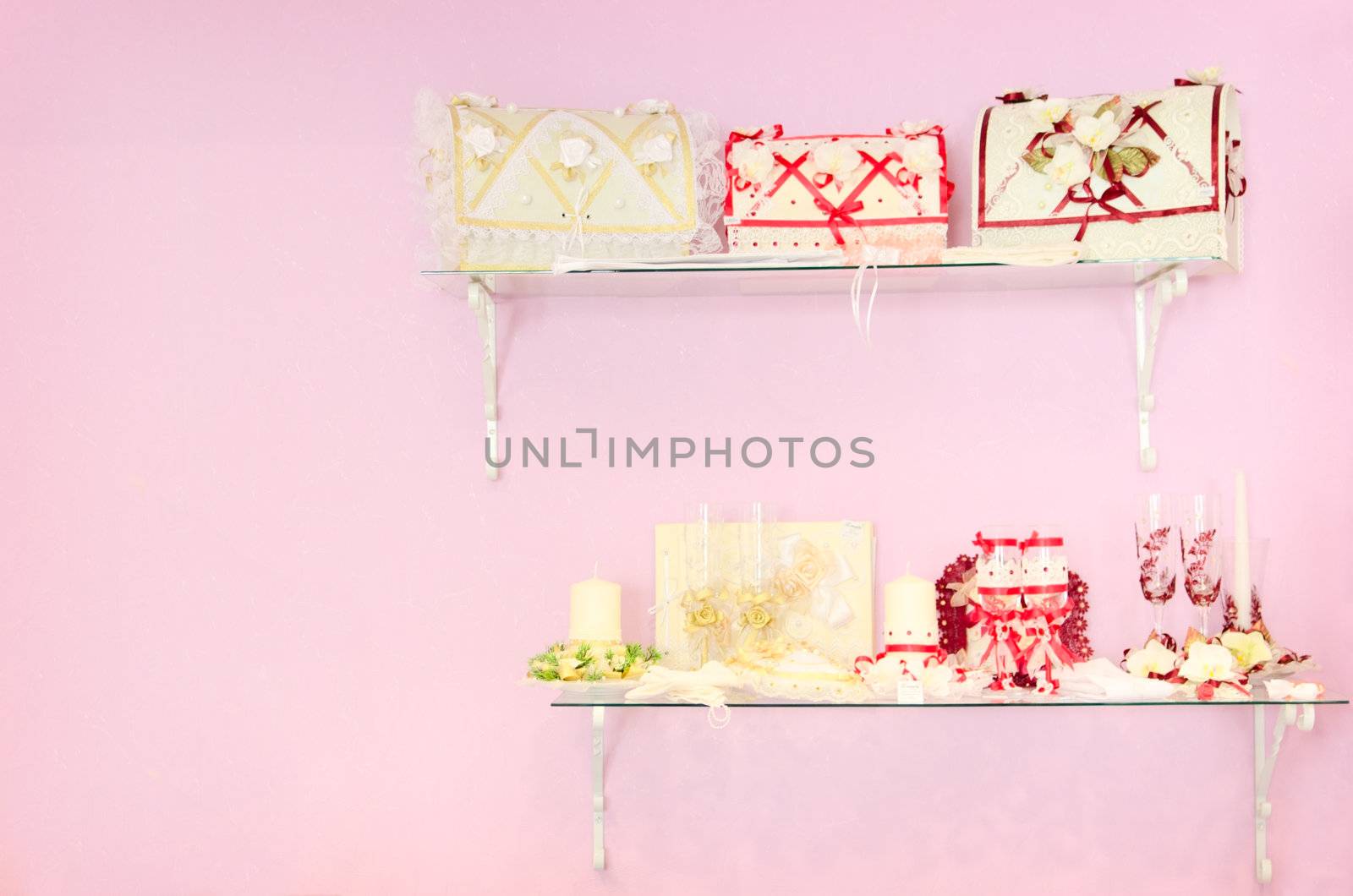 Wedding store background. Pink wall and different stuff on glass shelfs