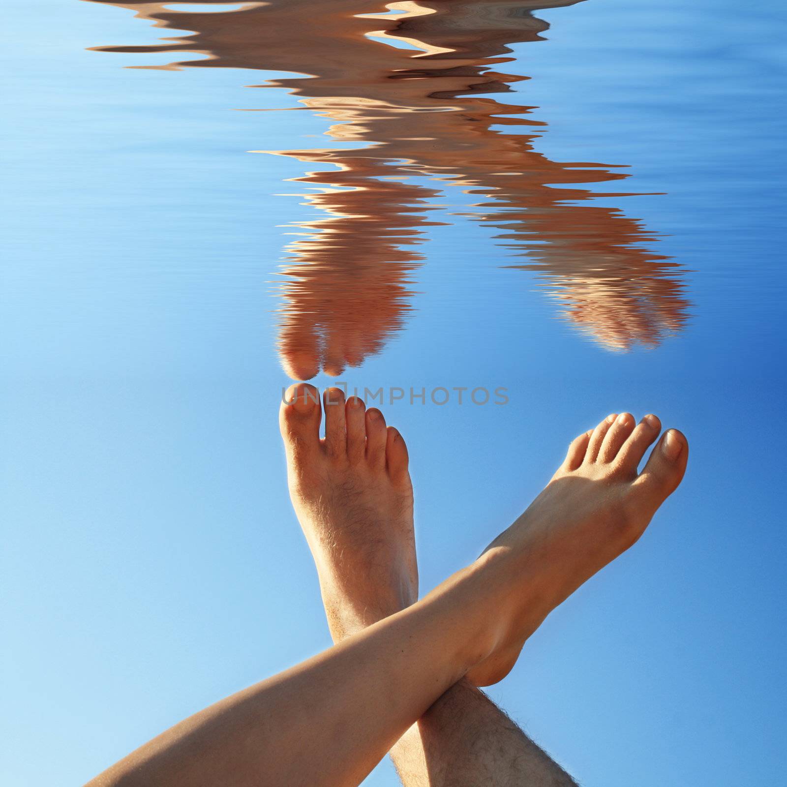 human legs on the blue water in summer by photochecker