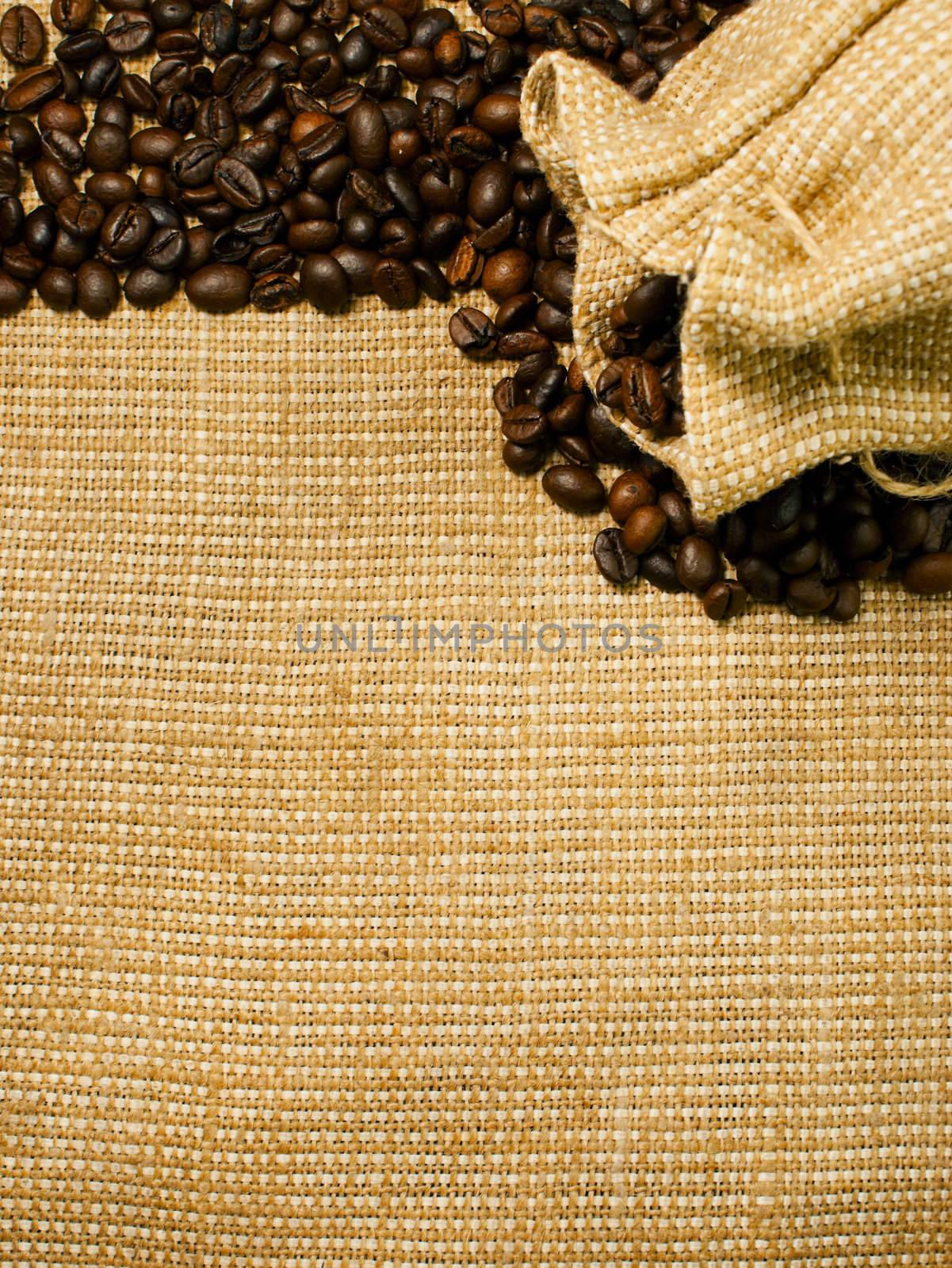 Background of the roasted coffee beans on a burlap piece