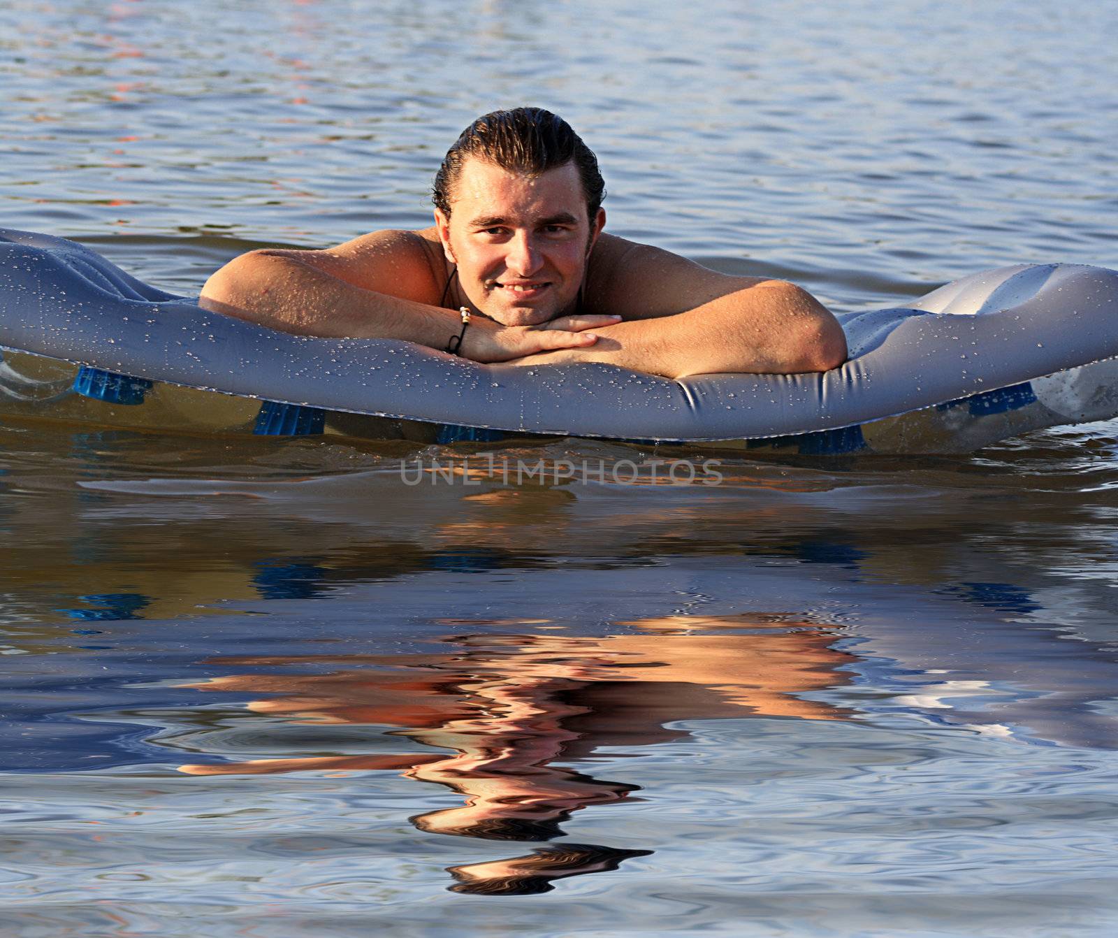 man air mattress in the lake by photochecker
