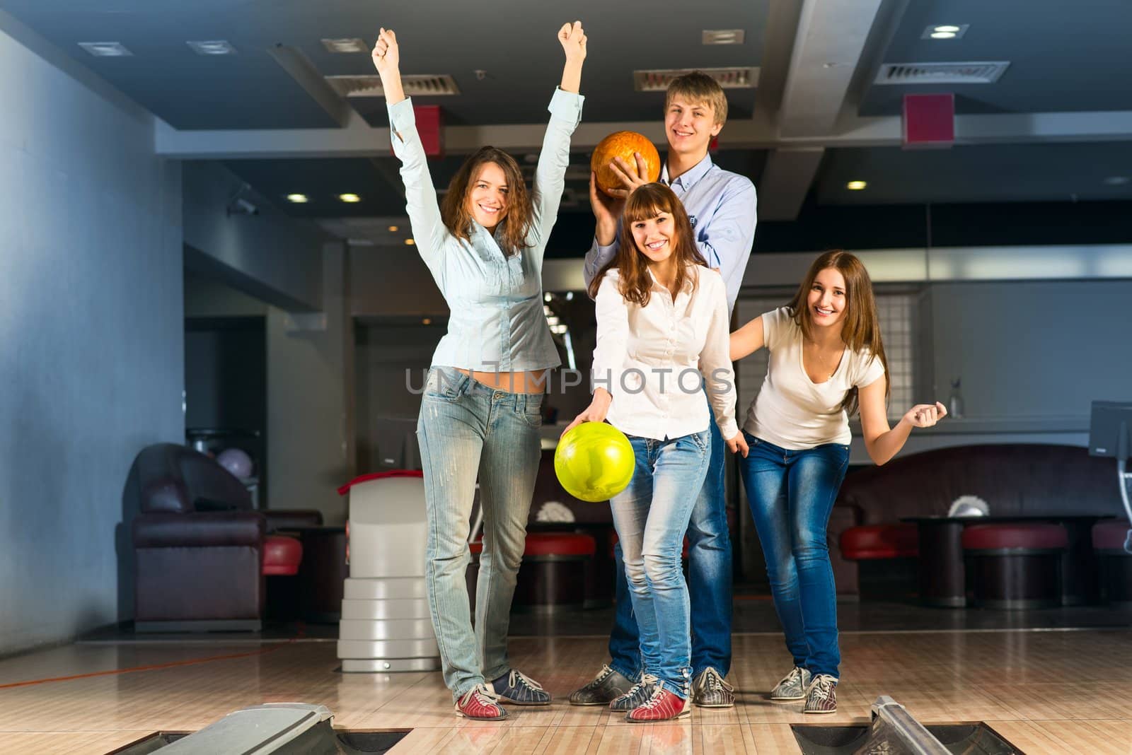 Group of young friends playing bowling, spending time with friends