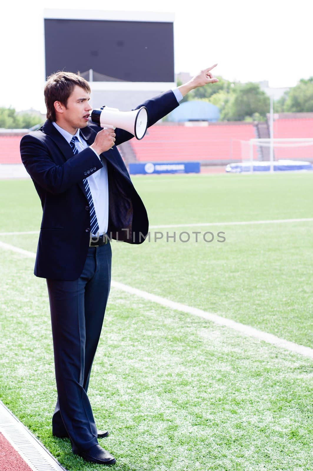 athletic trainer instructs the team on the pitch