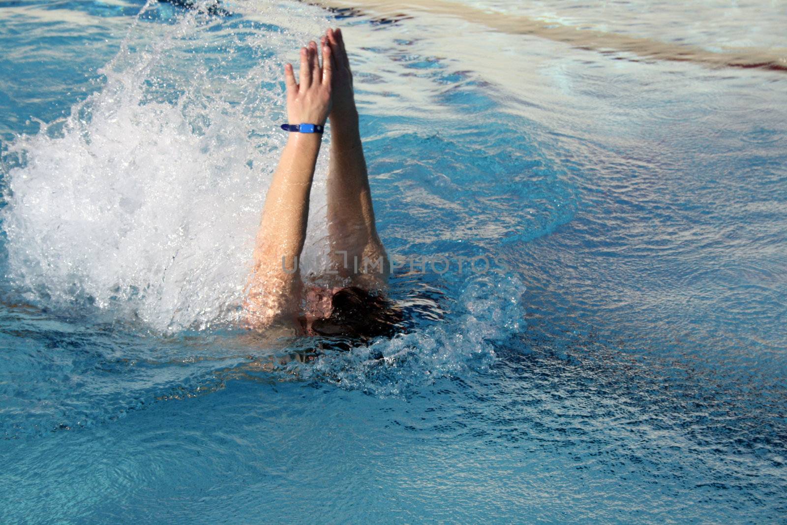 young man swimming backstroke by photochecker