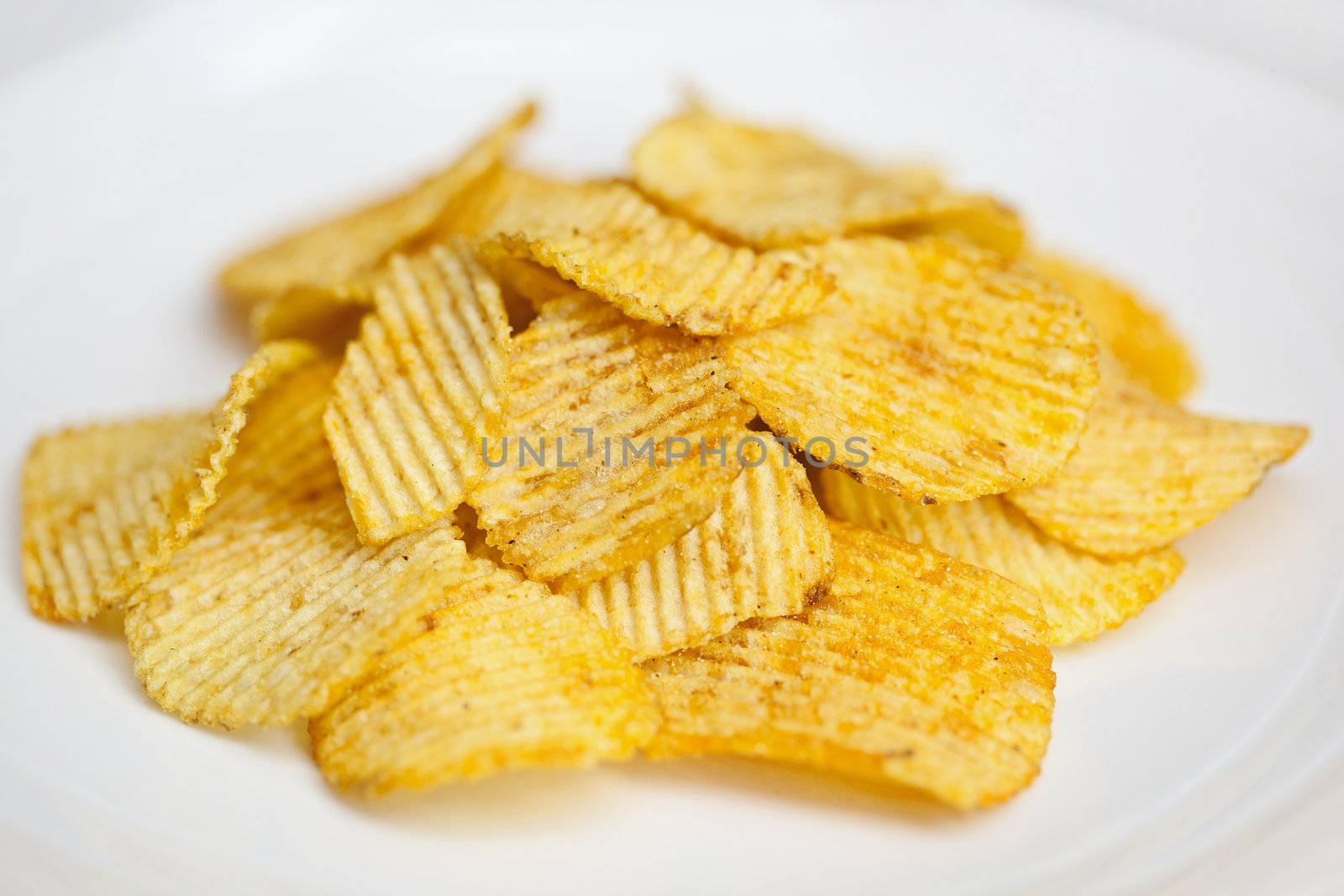 Ribbed potato chips on a plate closeup