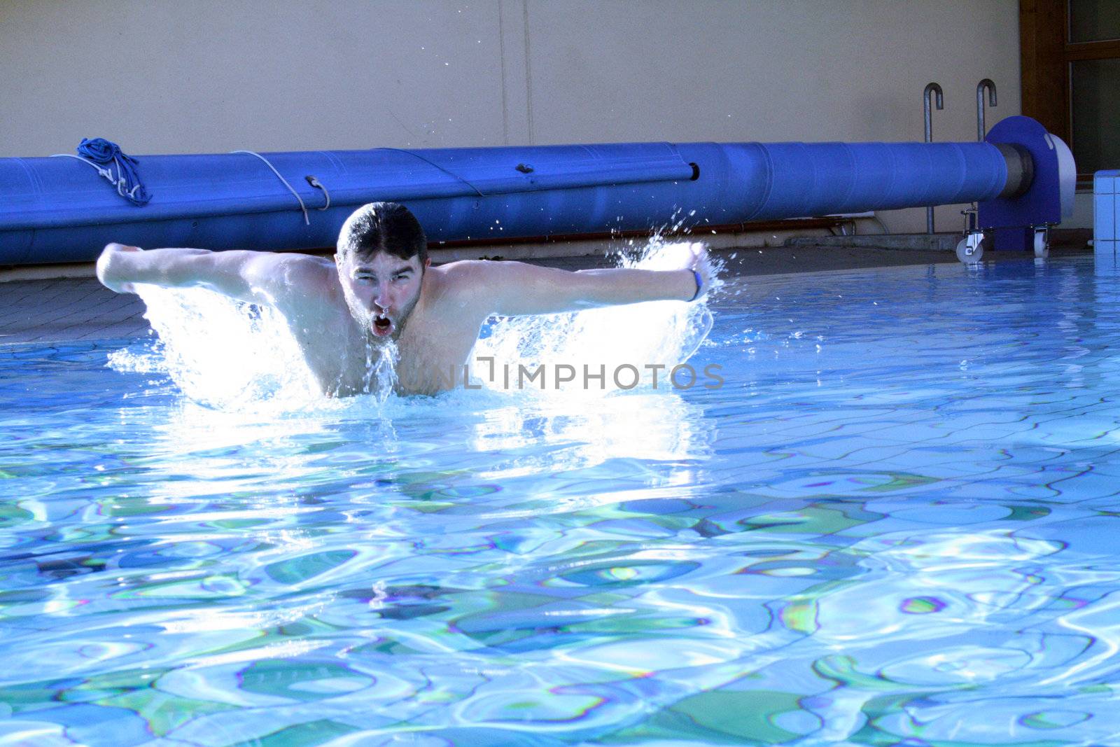 man swims in swimming pool