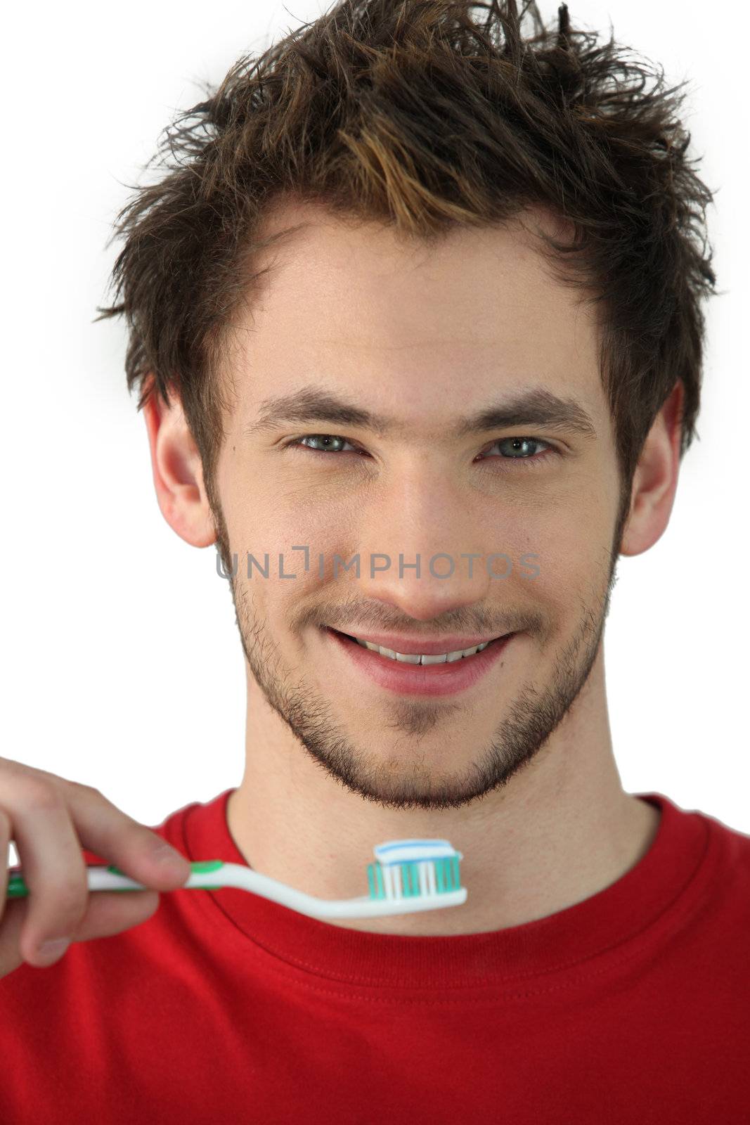 Young man holding a toothbrush by phovoir