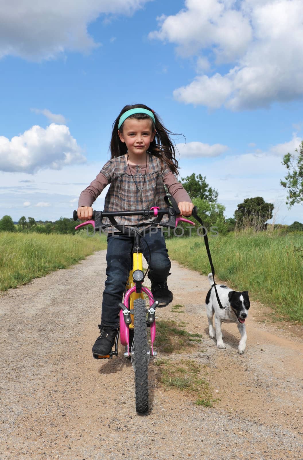 little girl with her jack russel terrier on a bicycle