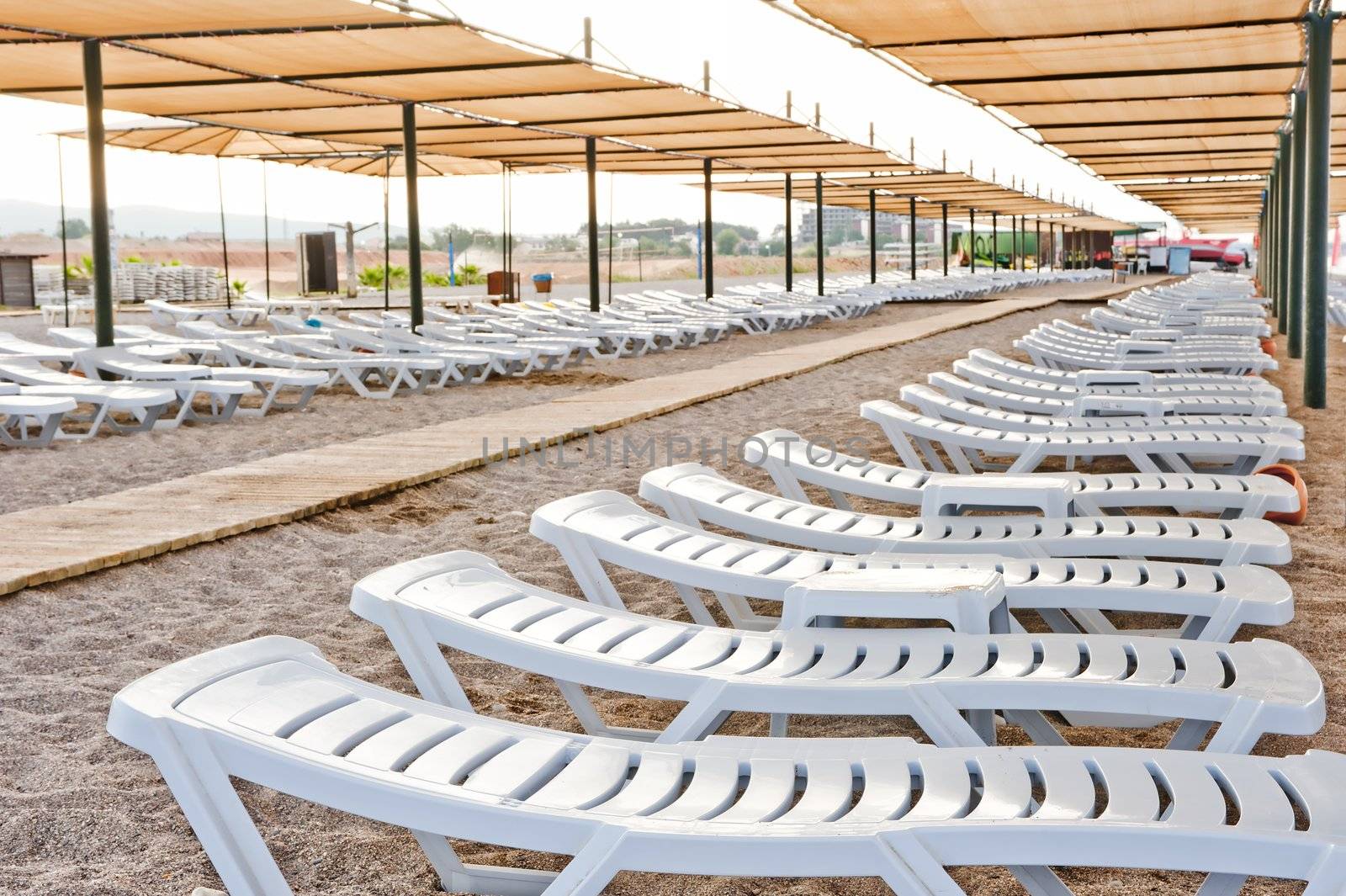 Beach chairs under a canopy on a sandy beach