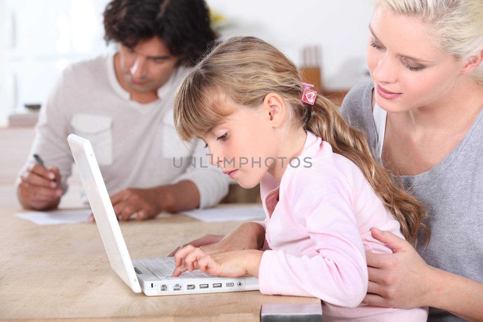 Parents with daughter on computer by phovoir