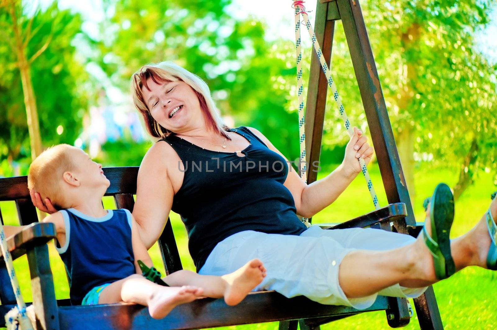 Happy grandmother and grandson on a swing