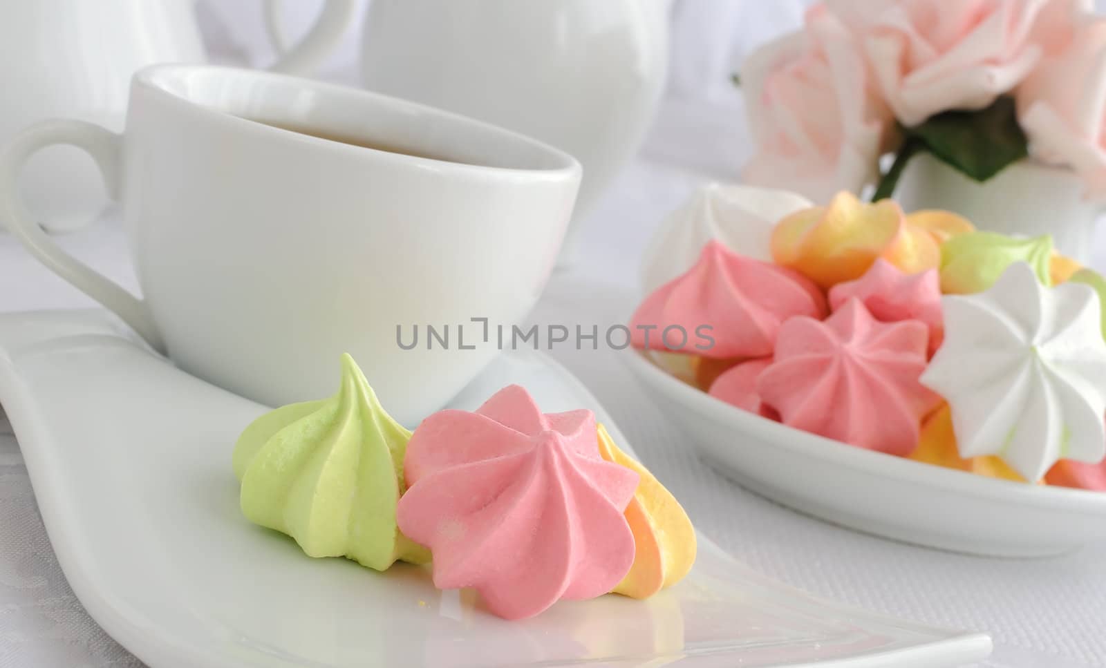Meringue cookies on a plate with a cup of coffee by Apolonia