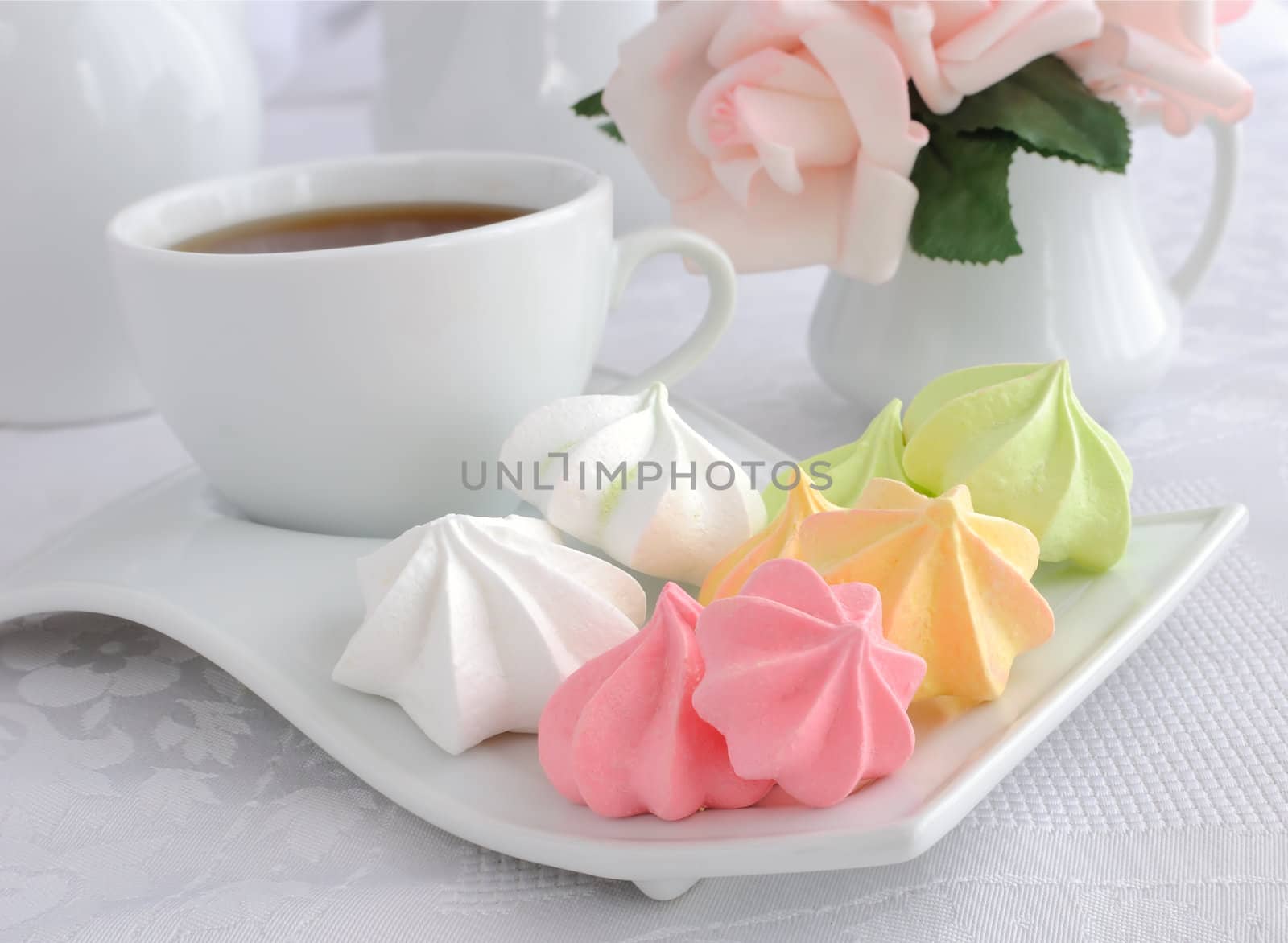 A cup of coffee and biscuits meringue on a plate closeup