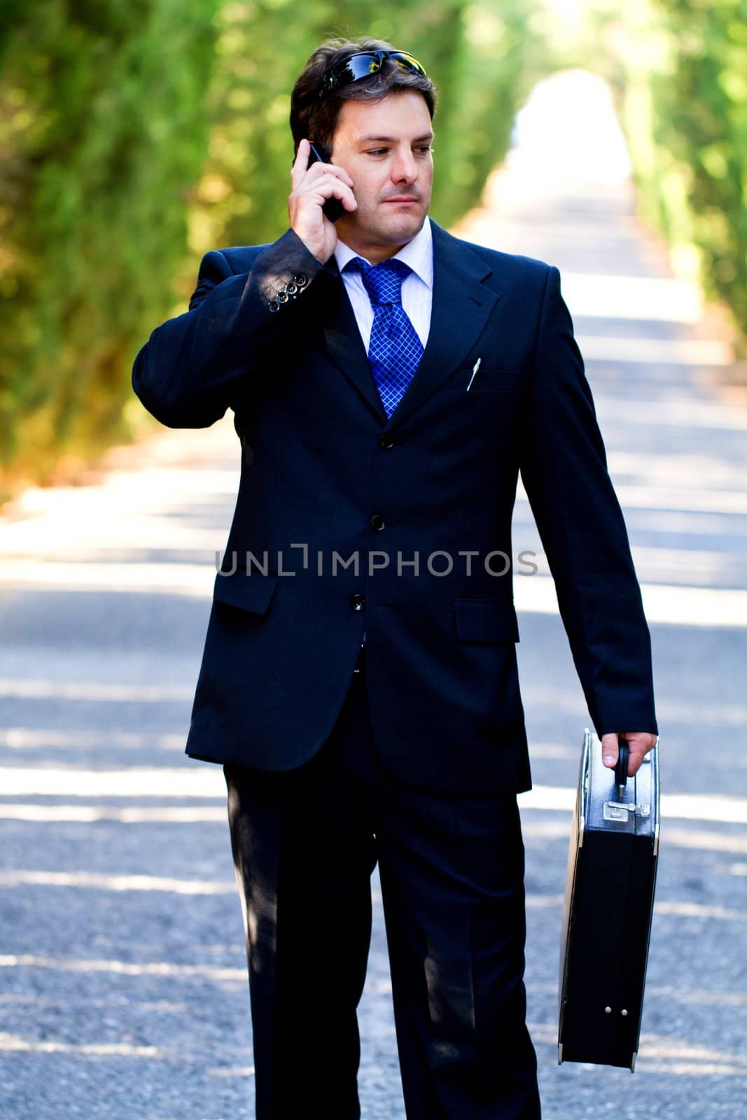 View of a young male business man on a asphalt road.