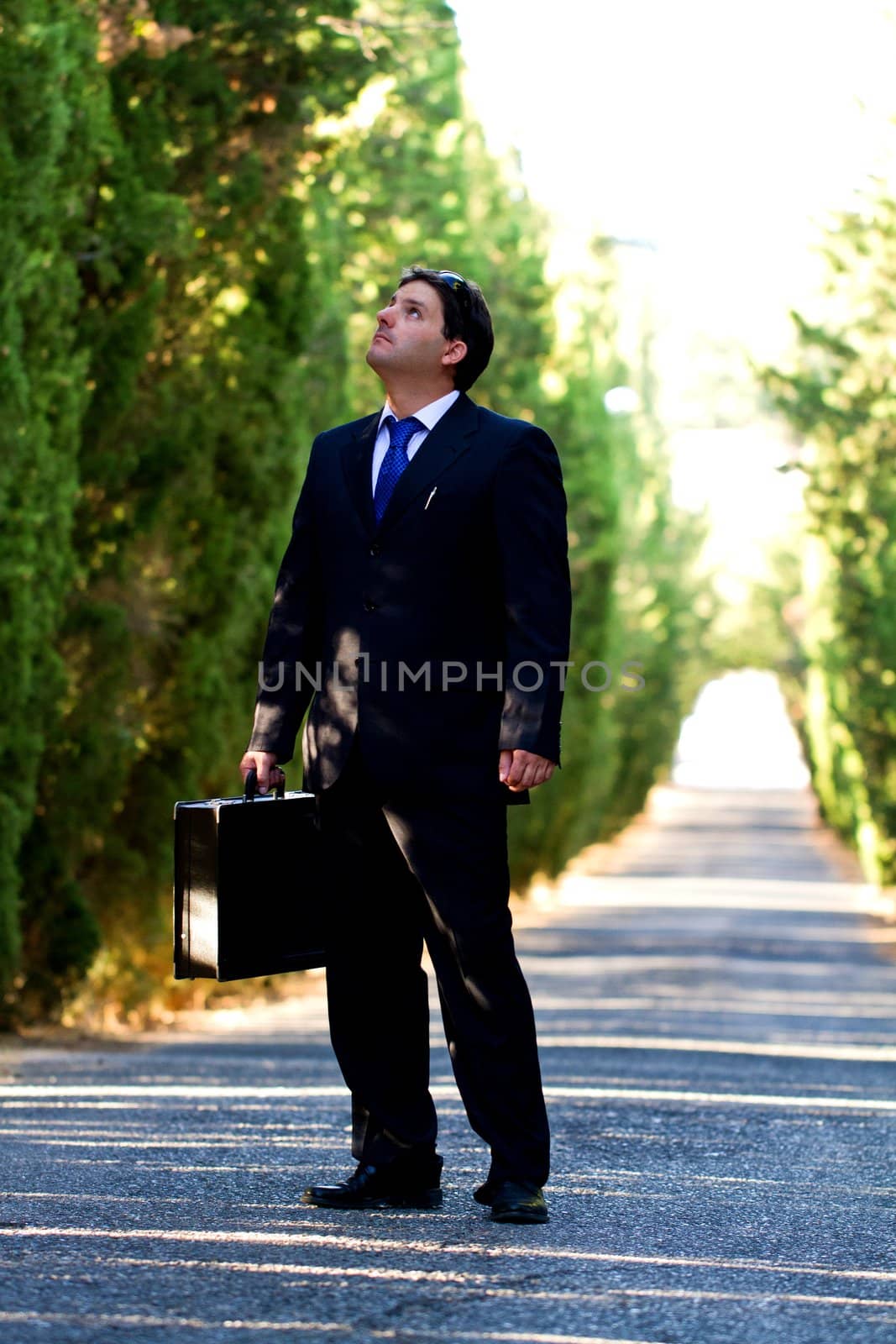 View of a young male business man on a asphalt road.