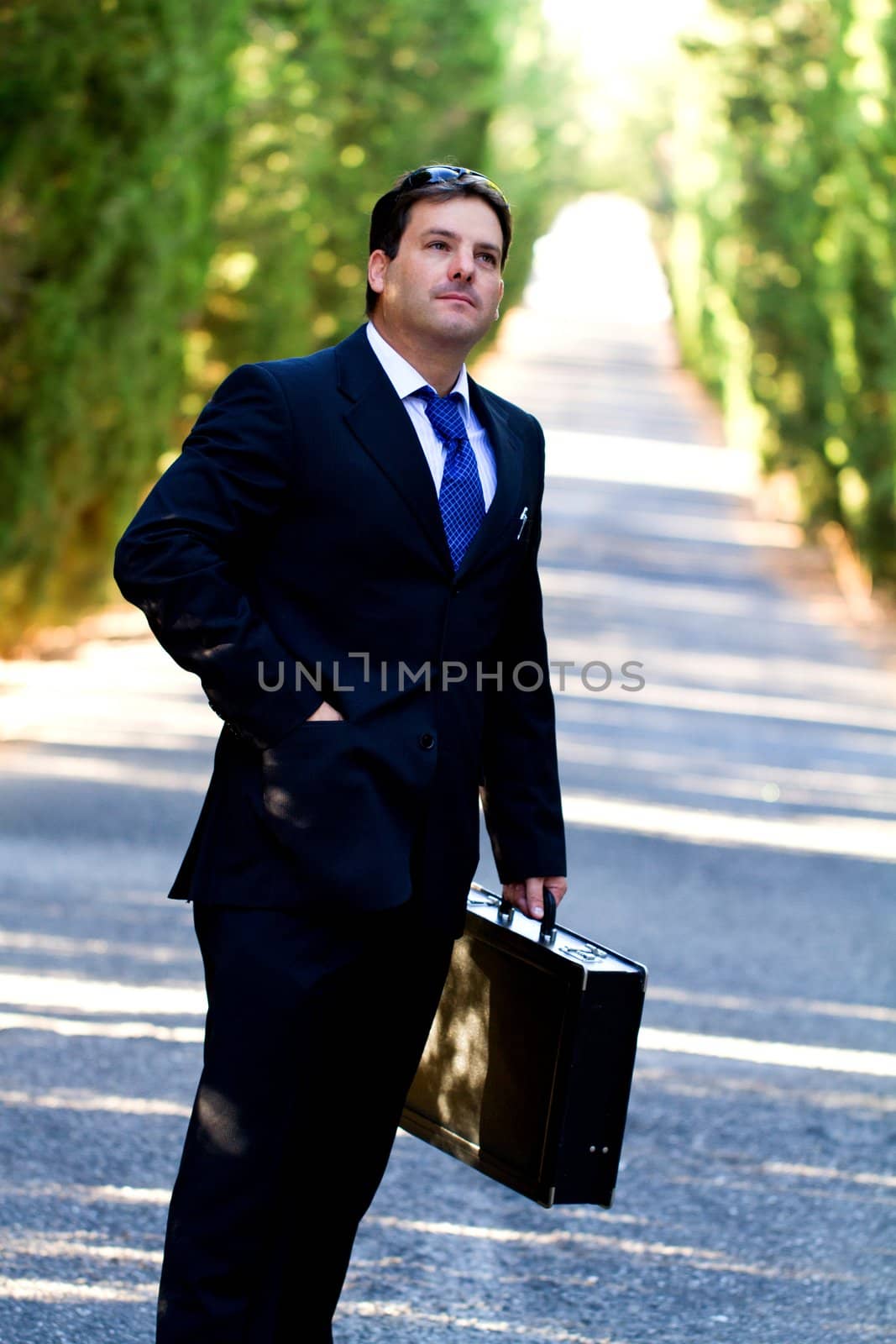 View of a young male business man on a asphalt road.
