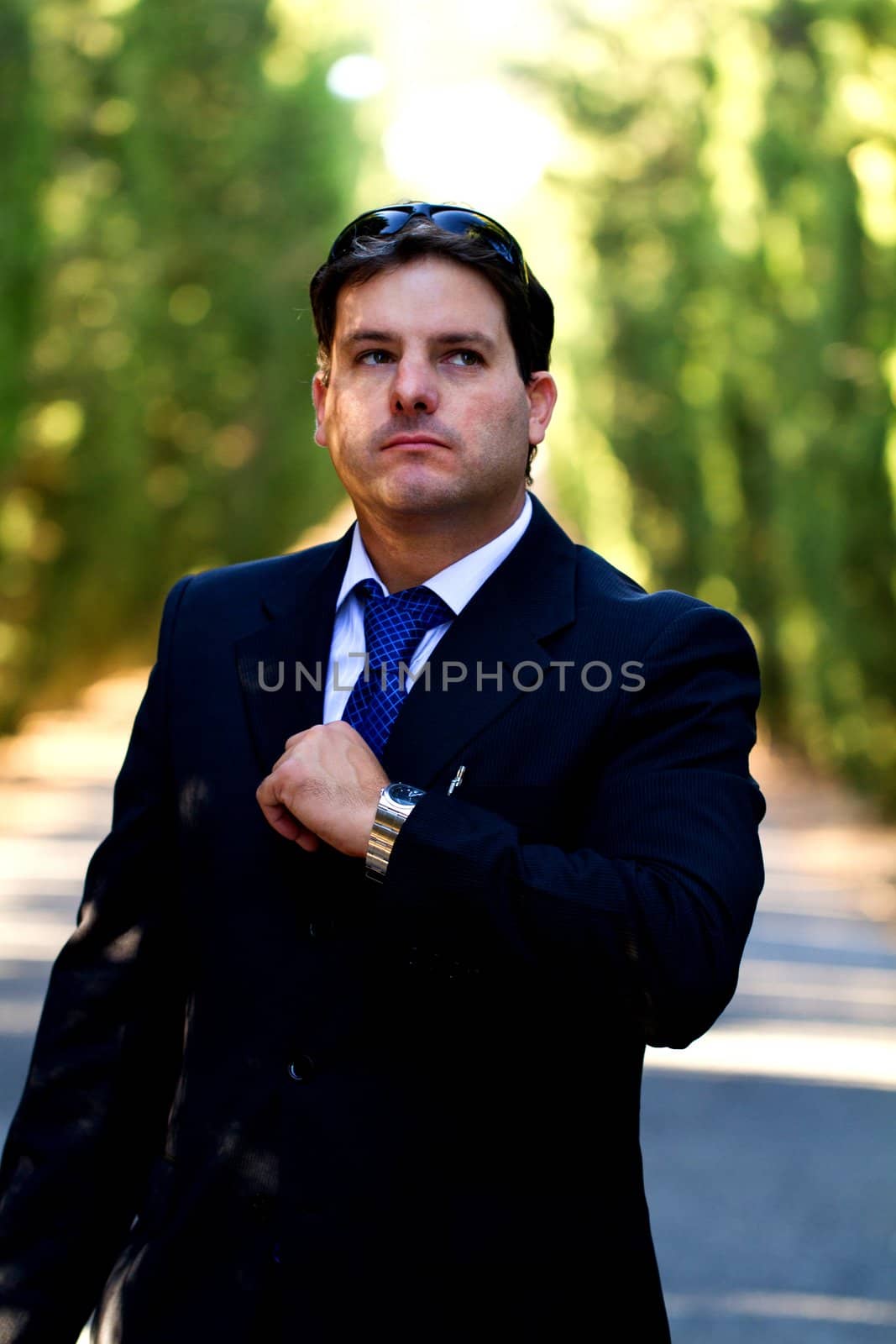 View of a young male business man on a asphalt road.