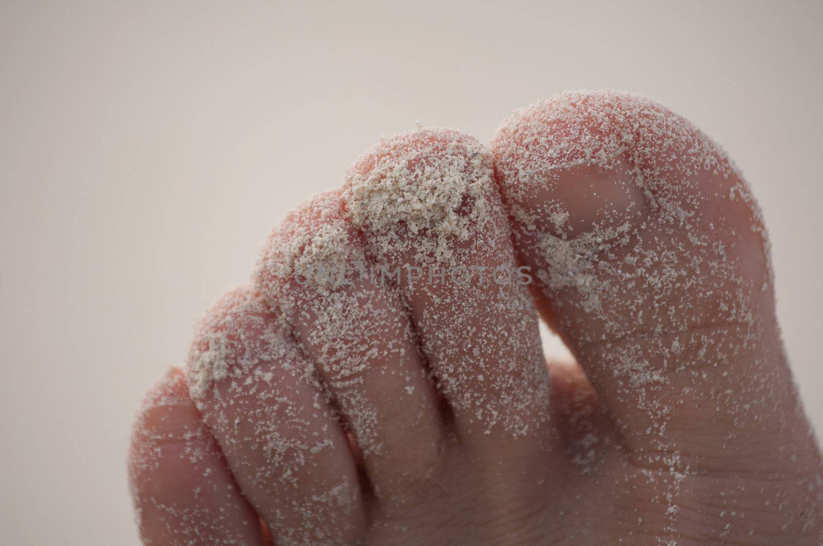 Image of toes covered with sand.