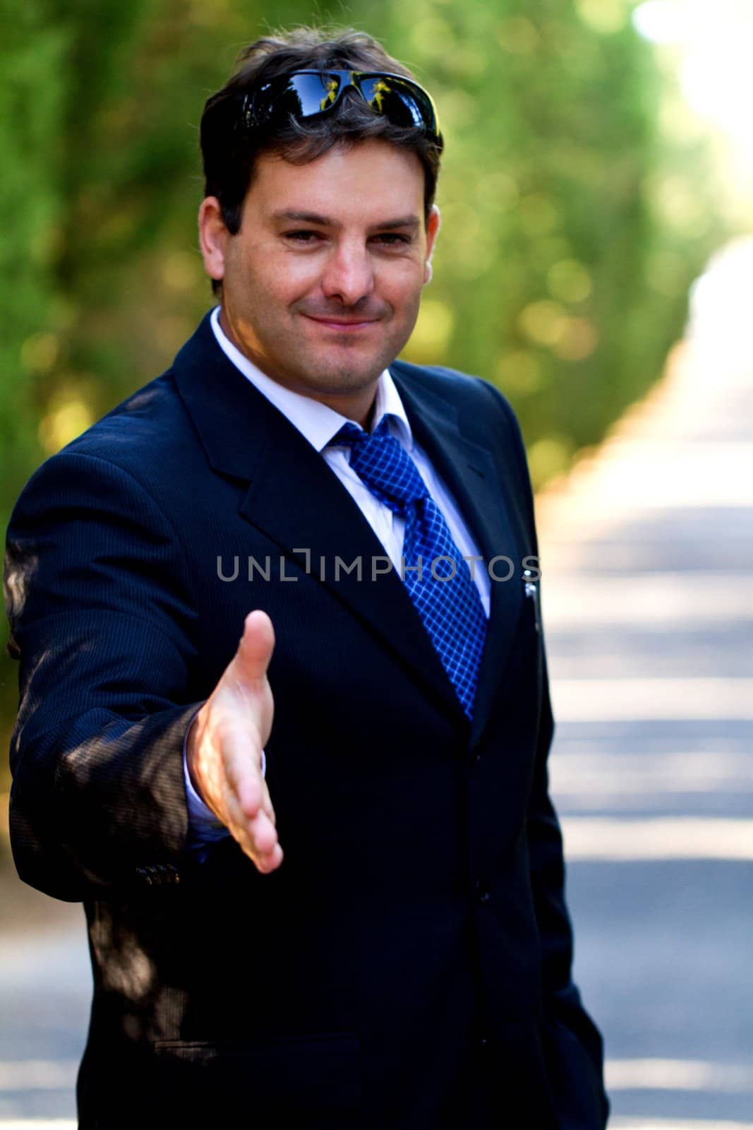 View of a young male business man on a asphalt road.