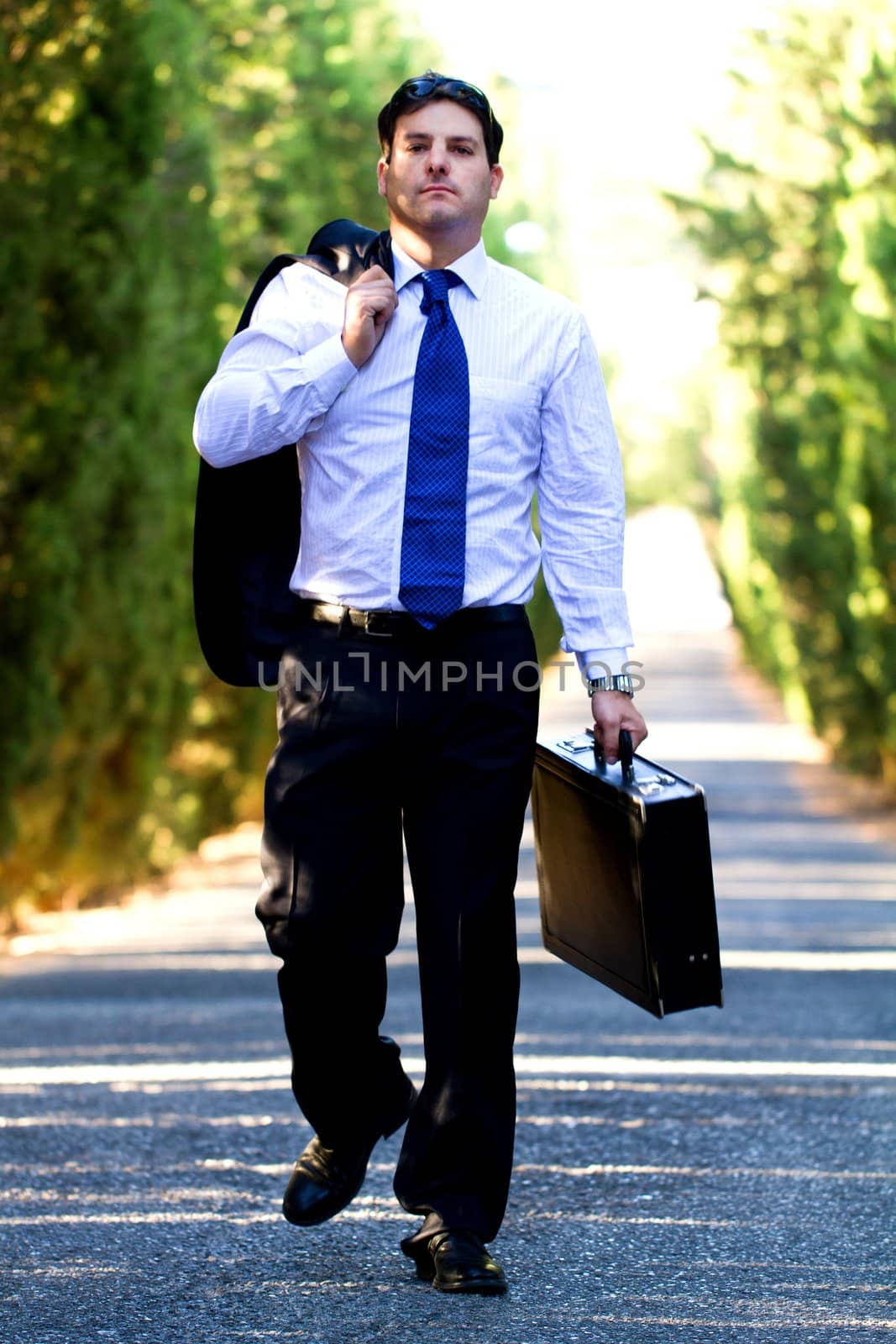 View of a young male business man on a asphalt road.