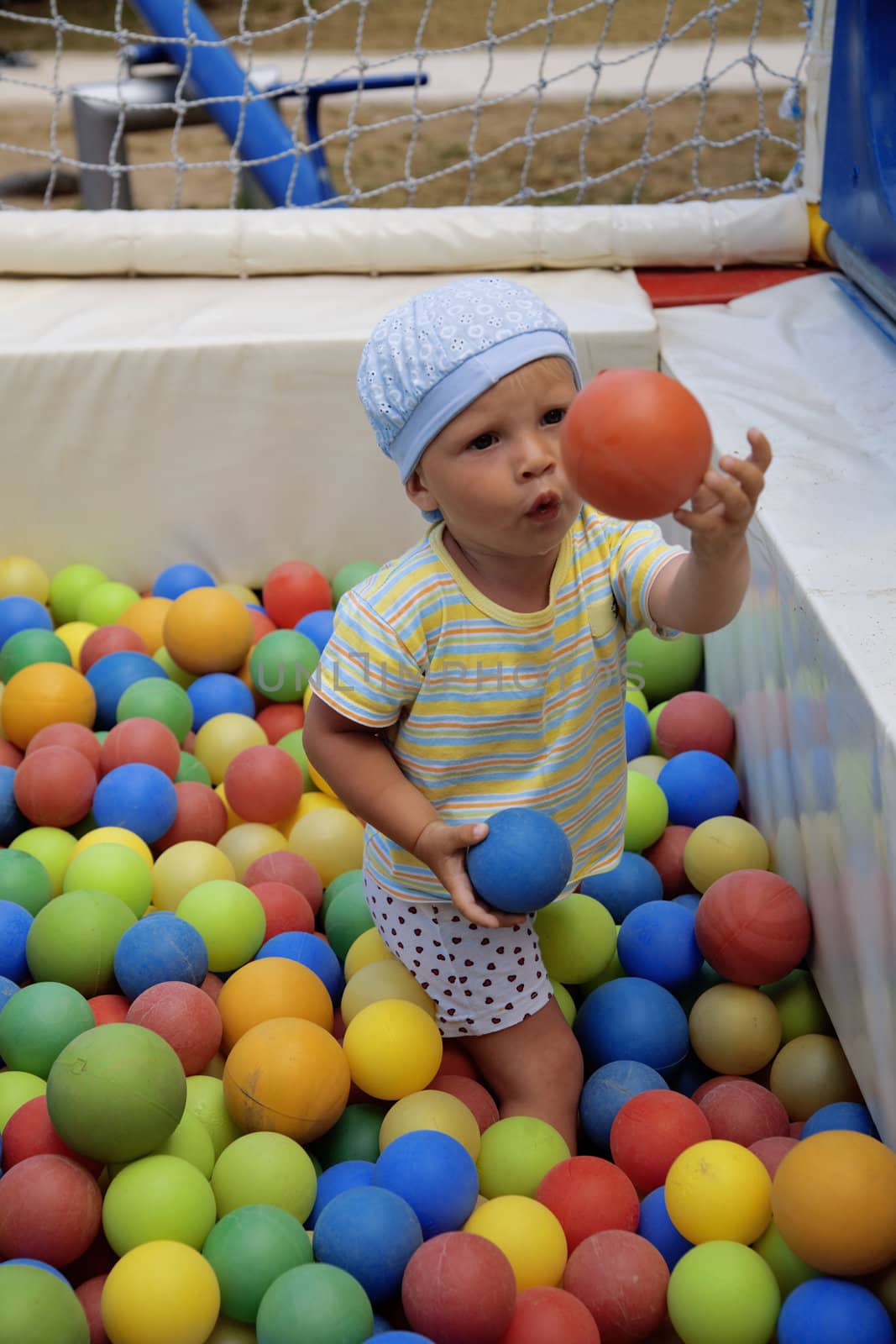 funny boy plays with varicoloured balls by Serp