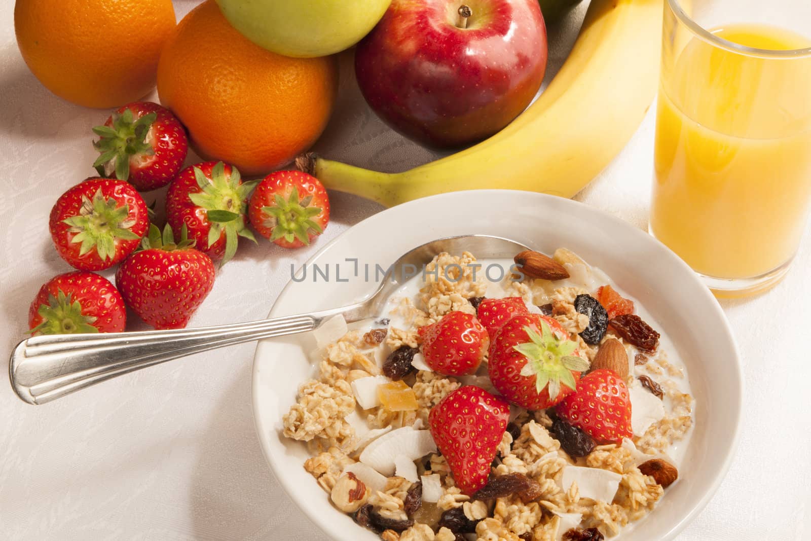 Bowl of cereal and fruits on tabletop - breakfast.