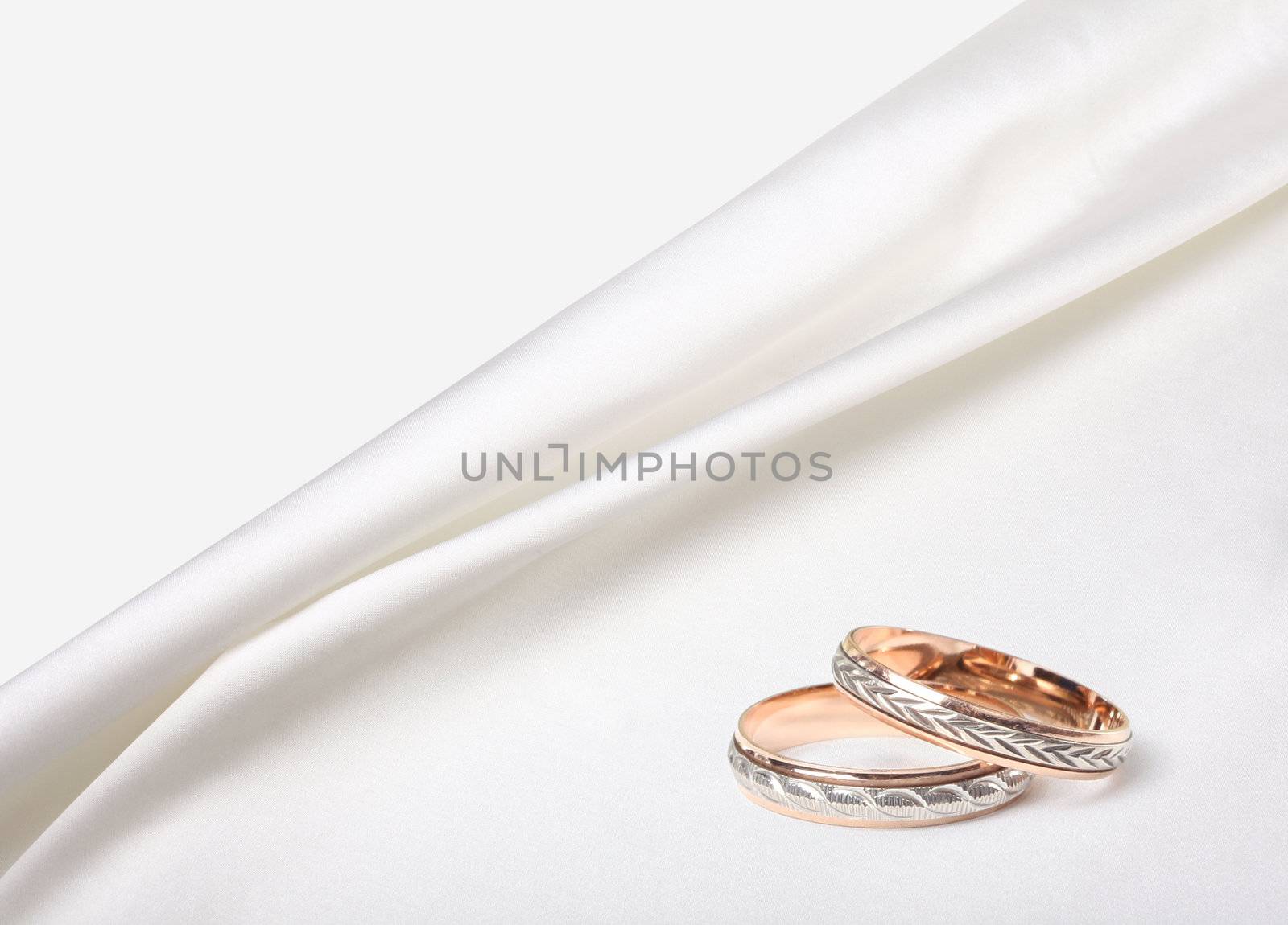 wedding rings on white silk background by rudchenko