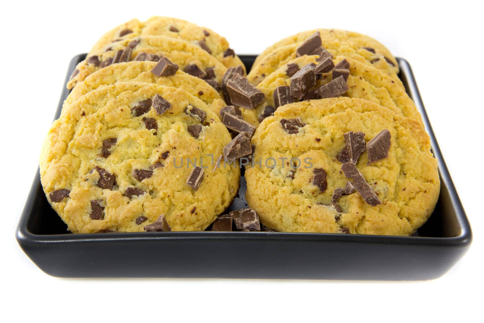 A picture of two stacks of some chocolate cookies with some chocolate on a black plate