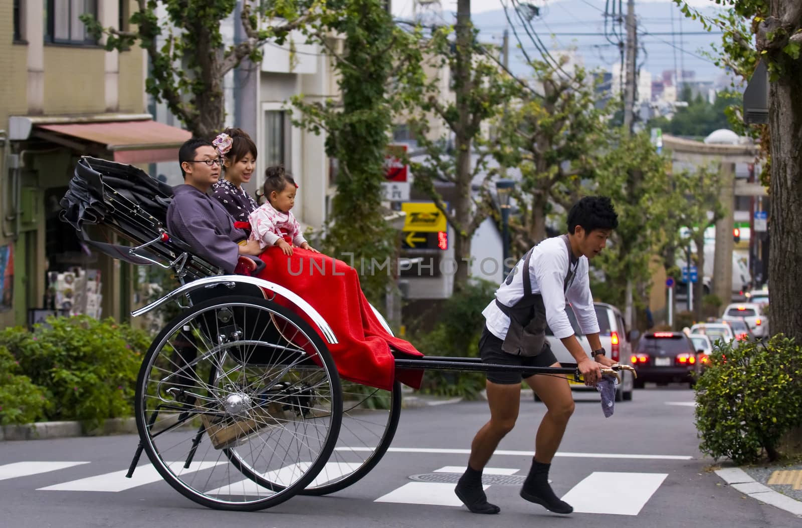 KYOTO , JAPAN - OCT 24 : Japanese family on a trditional rickshaw being pulled by a man on October 24 2009 in Kyoto , Japan