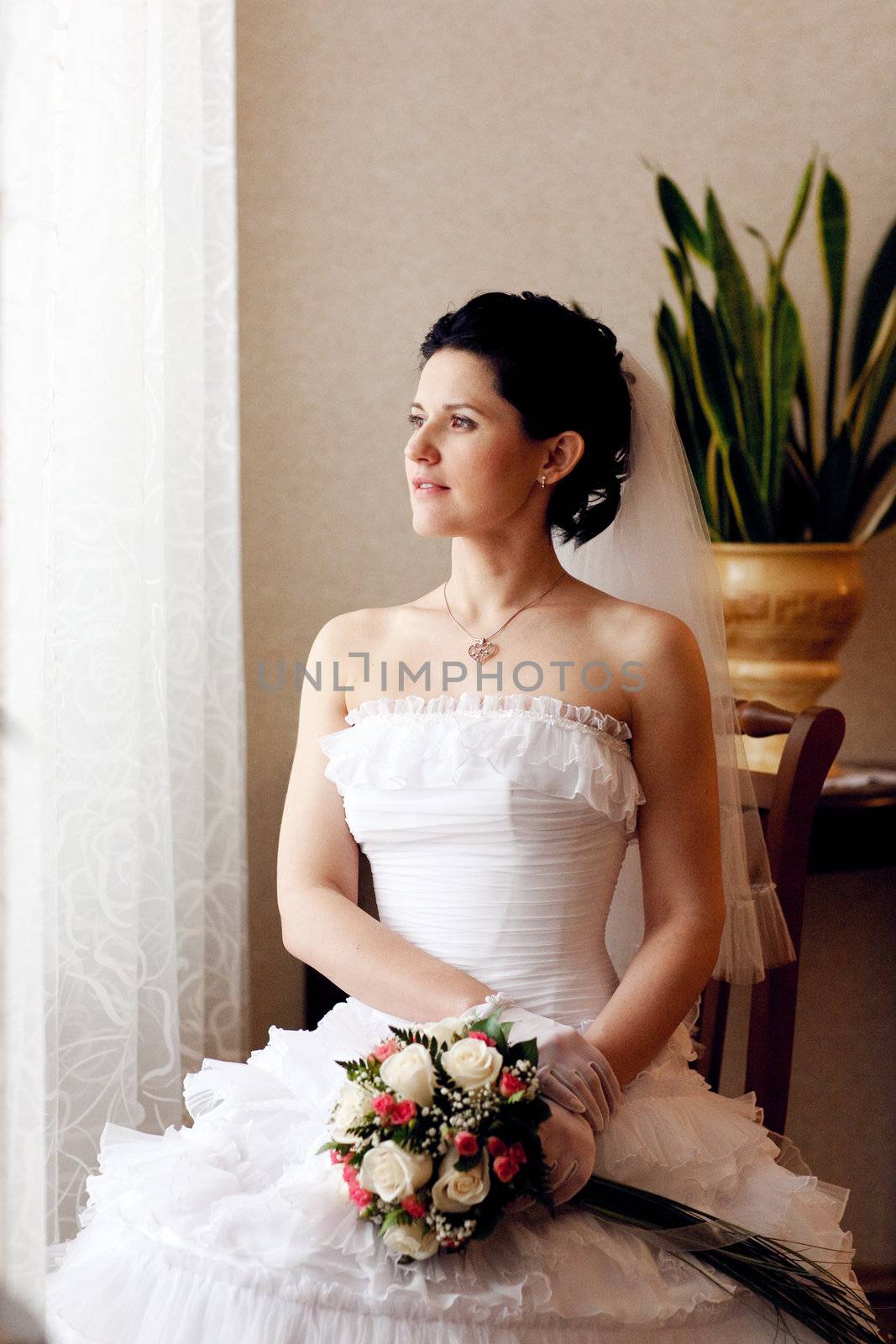 bride waiting for a groom near the window