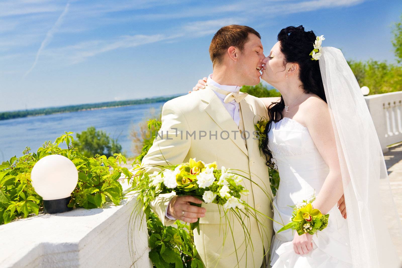 bride and groom kissing near the street lamp