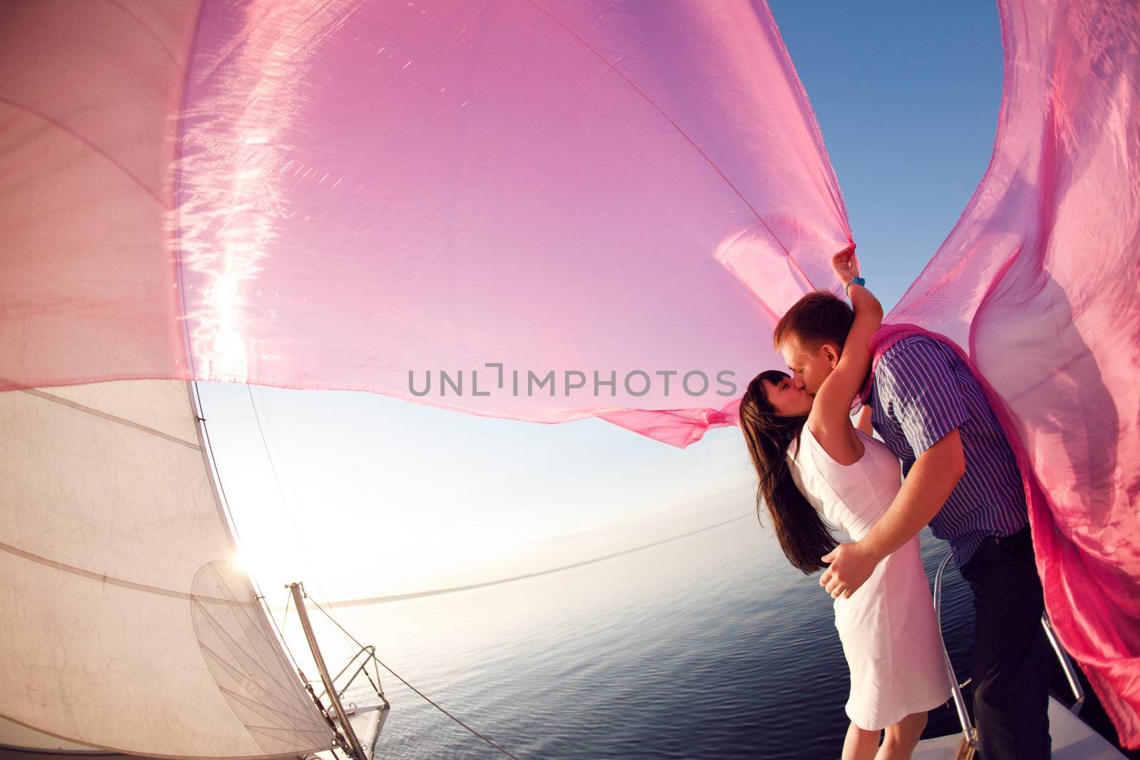 man and girl  kissing under the sail