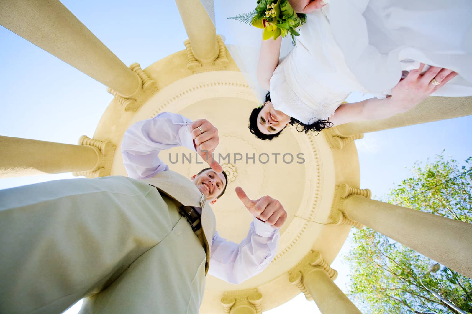 view up from bottom to bride and groom in columns
