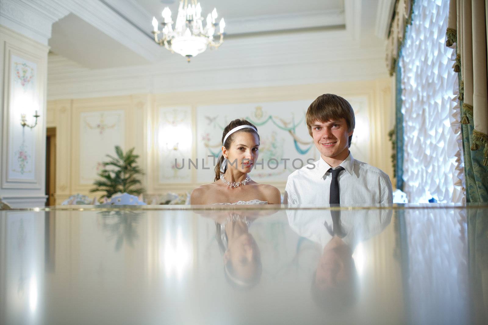 happy bride and groom at the piano