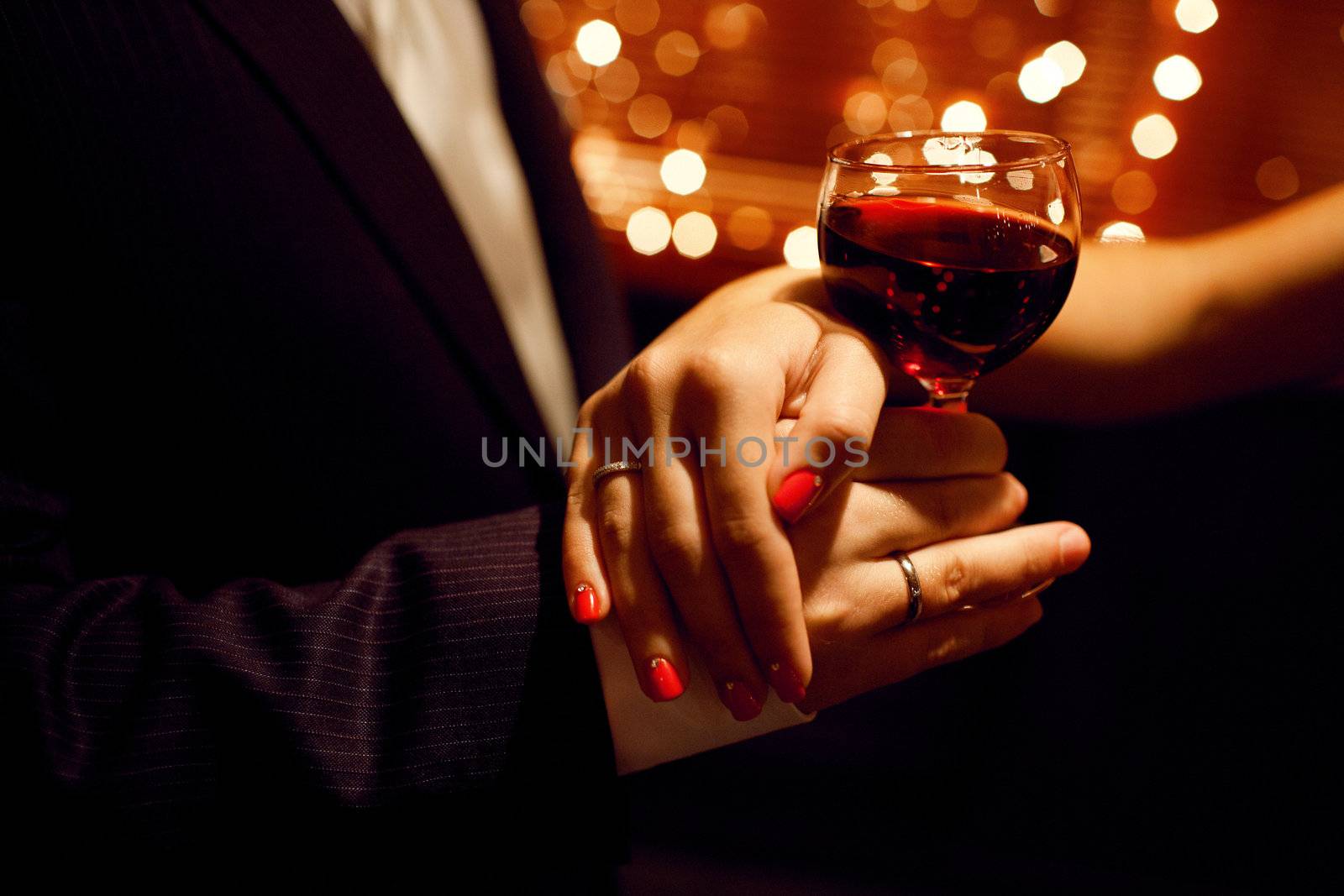 red wine glas in hands of lovers