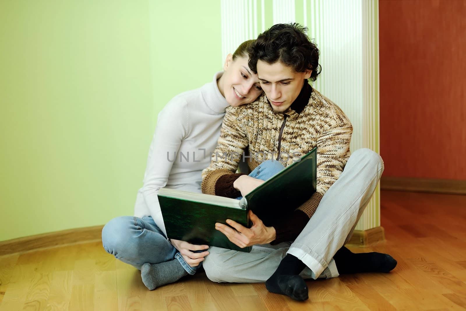 An image of young couple looking in album