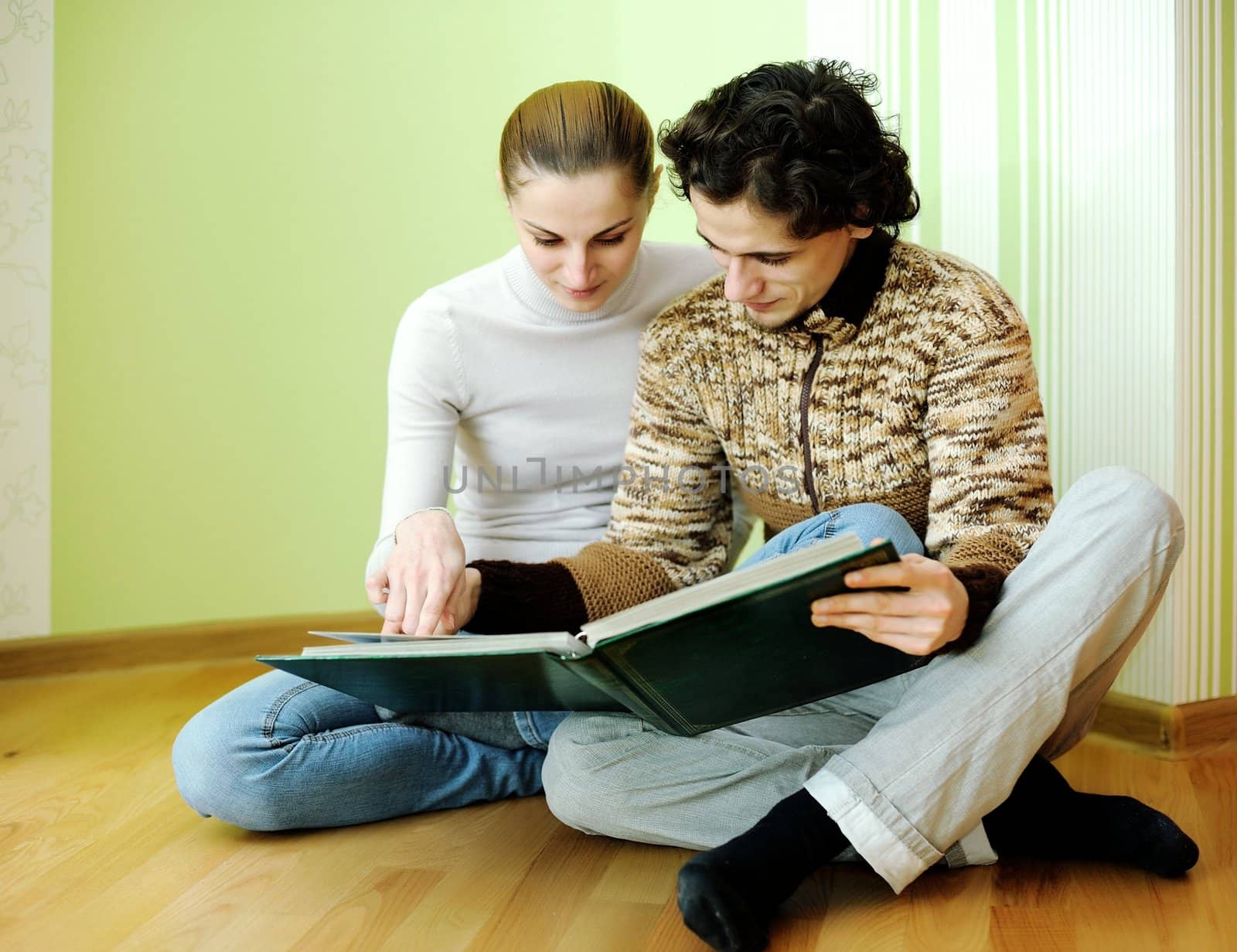 An image of young couple looking in album