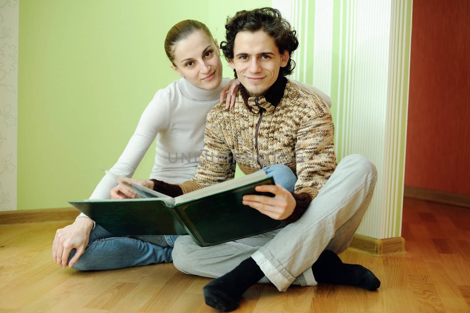 An image of young couple looking in album