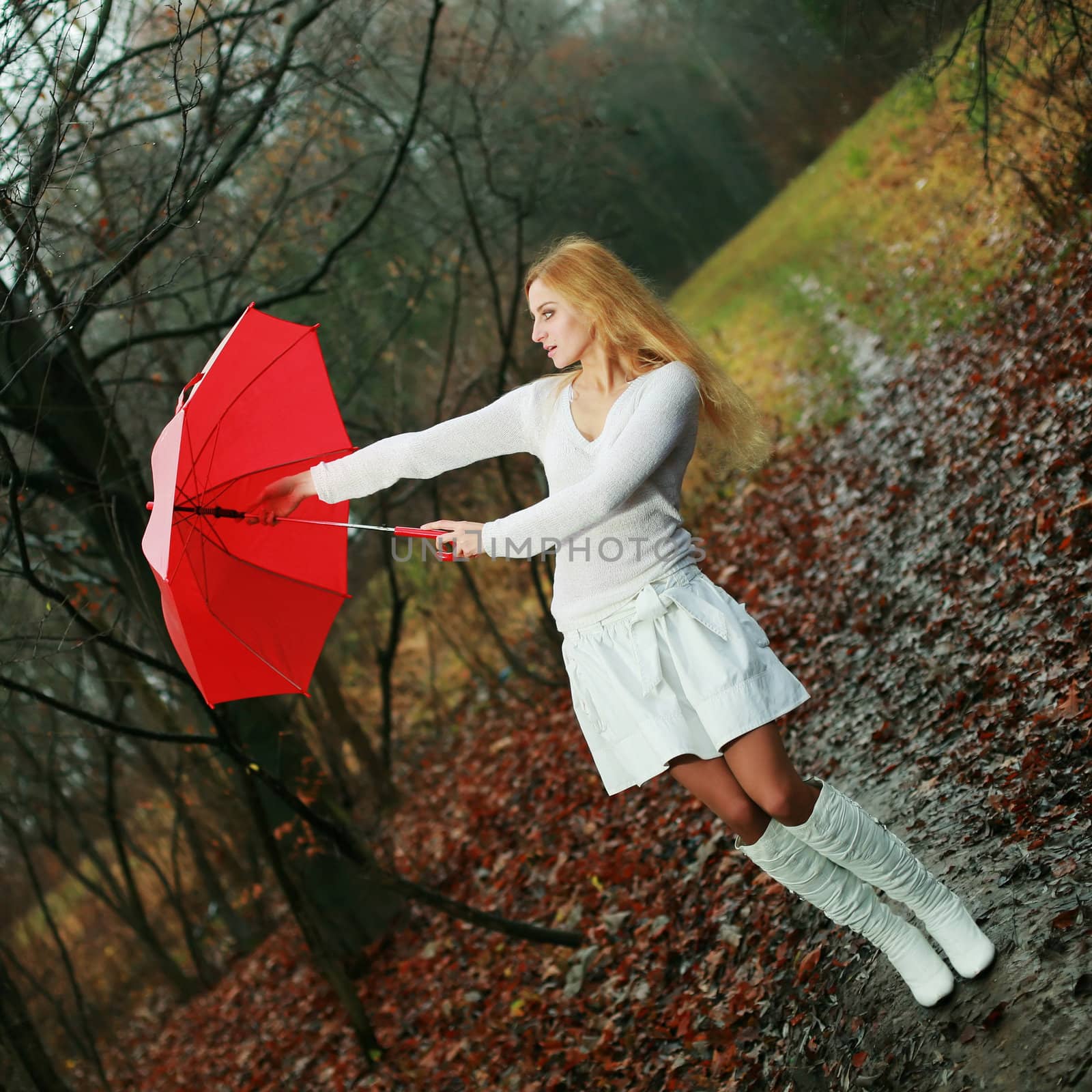 A woman with a red umbrella in autumn park