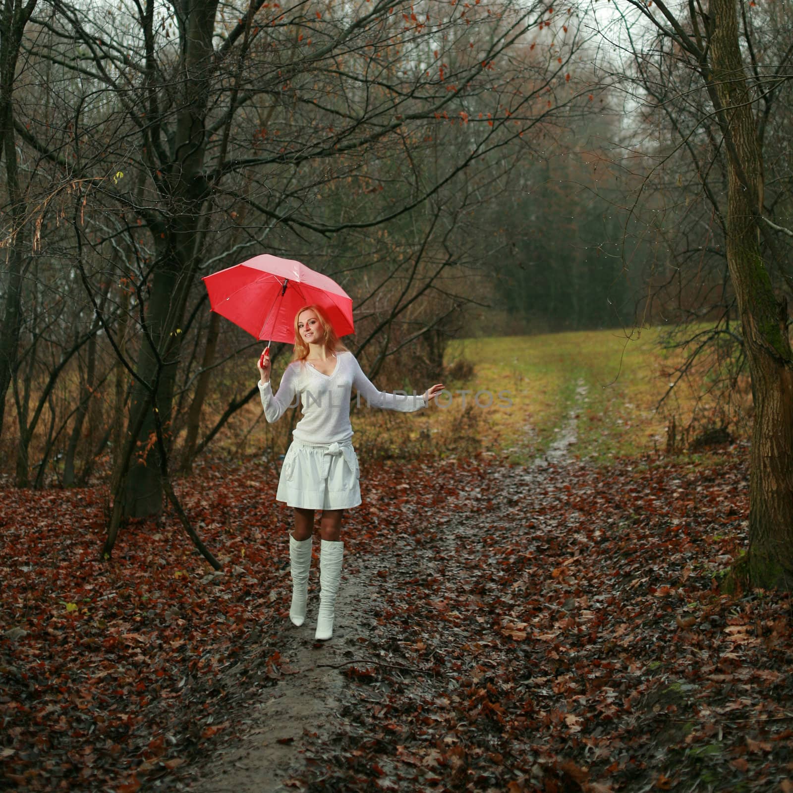 A woman with a red umbrella in autumn park