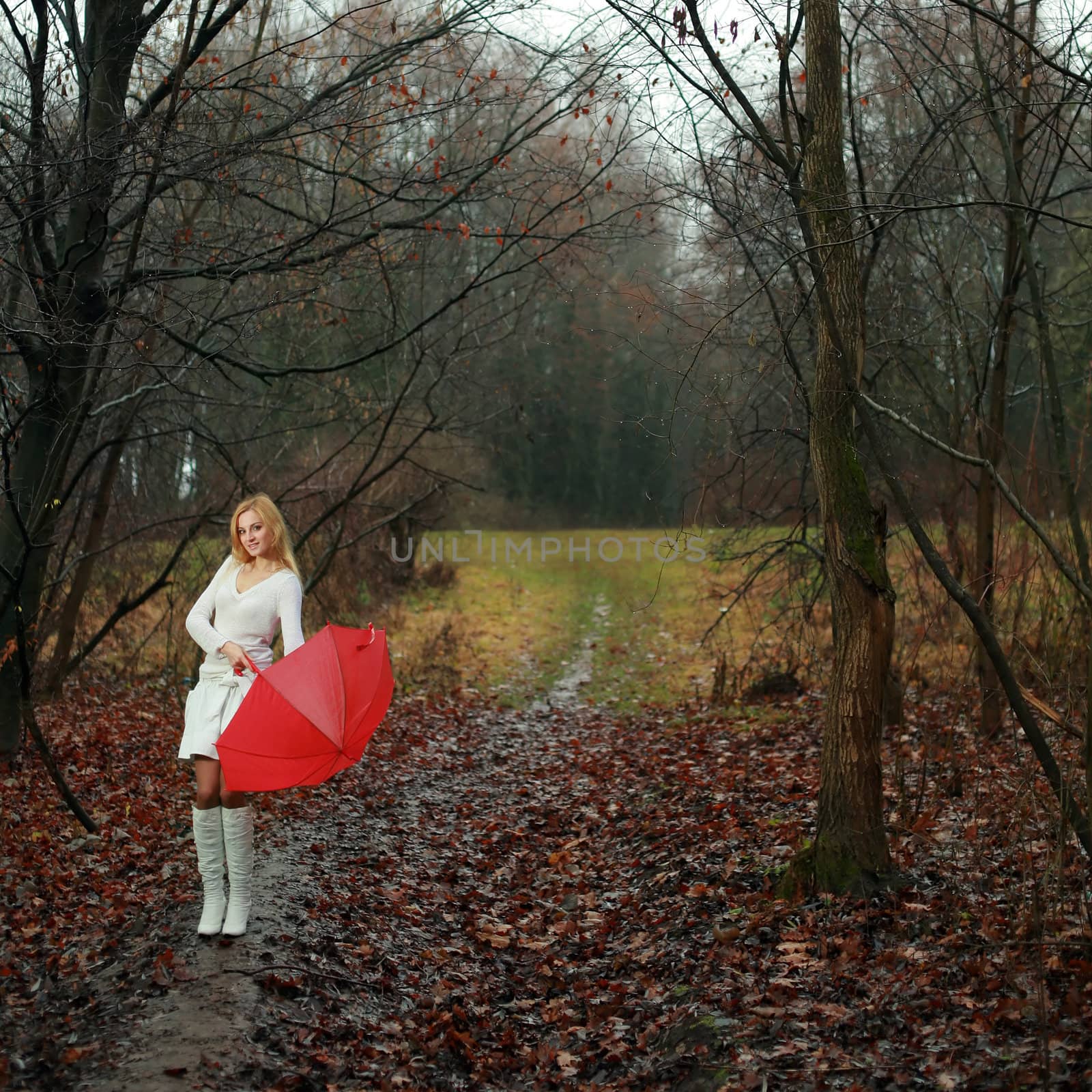 A woman with a red umbrella in autumn park