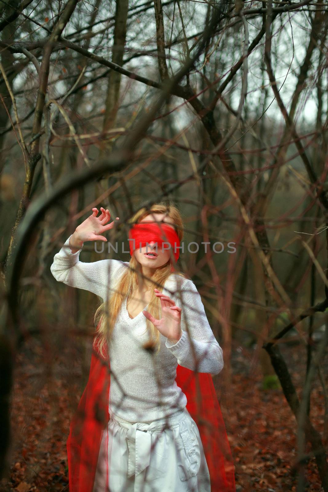An image of girl with red blindfold in a forest