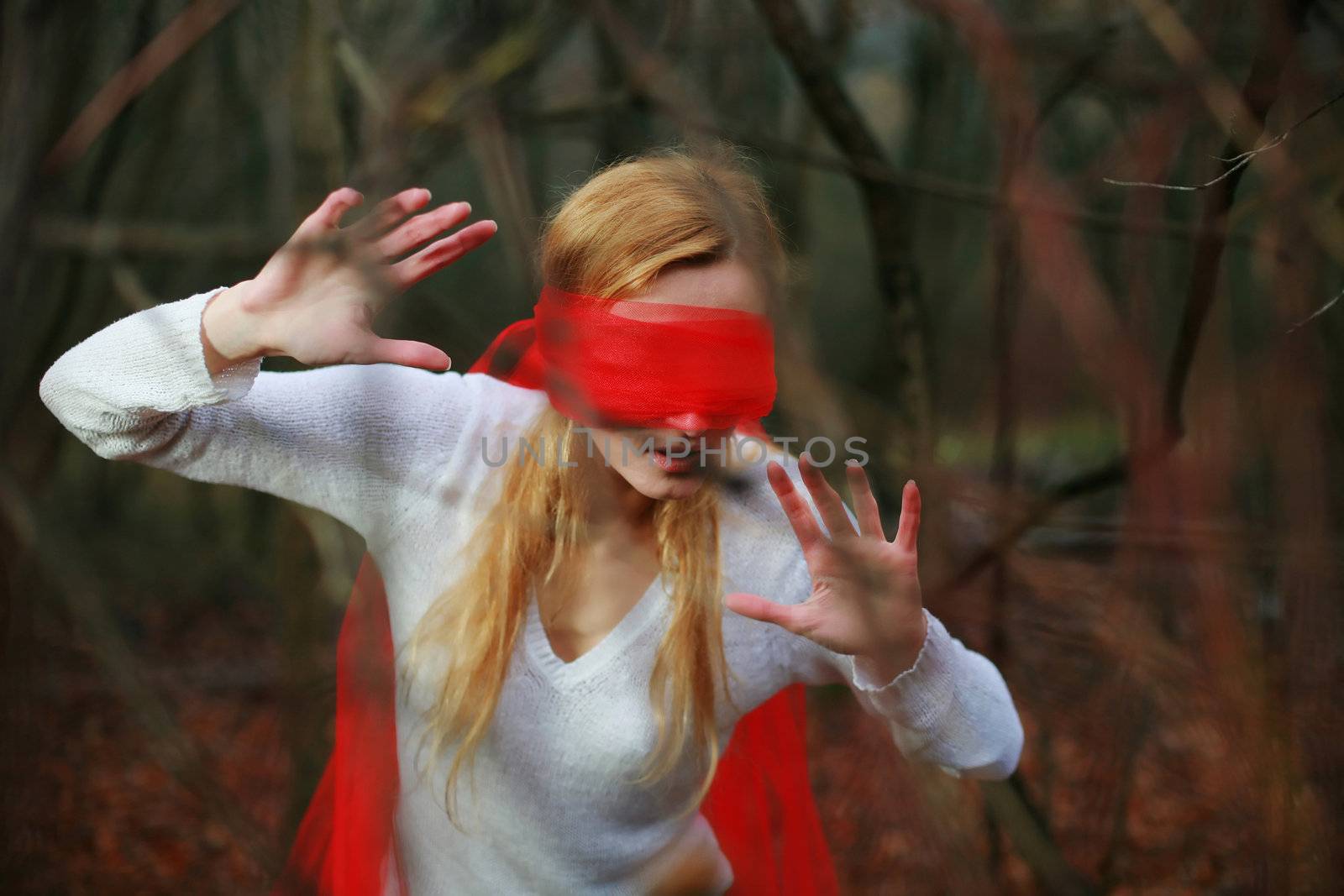 An image of woman with red blindfold in a forest