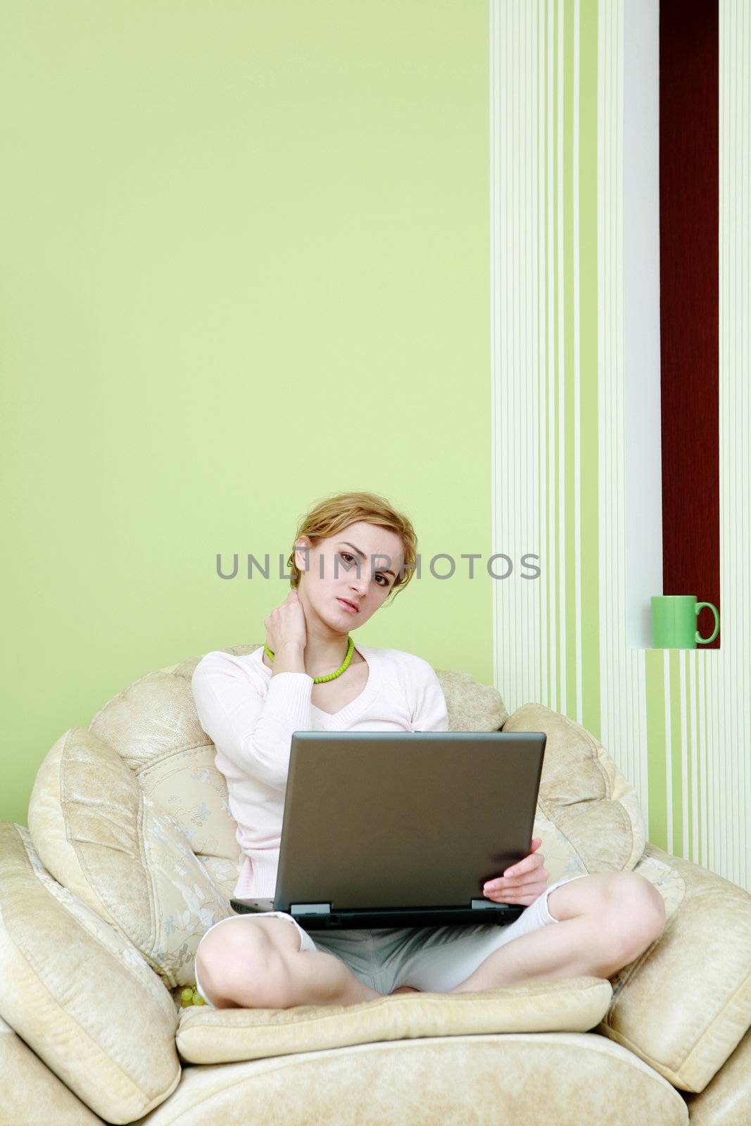 An image of a woman with a laptop in armchair
