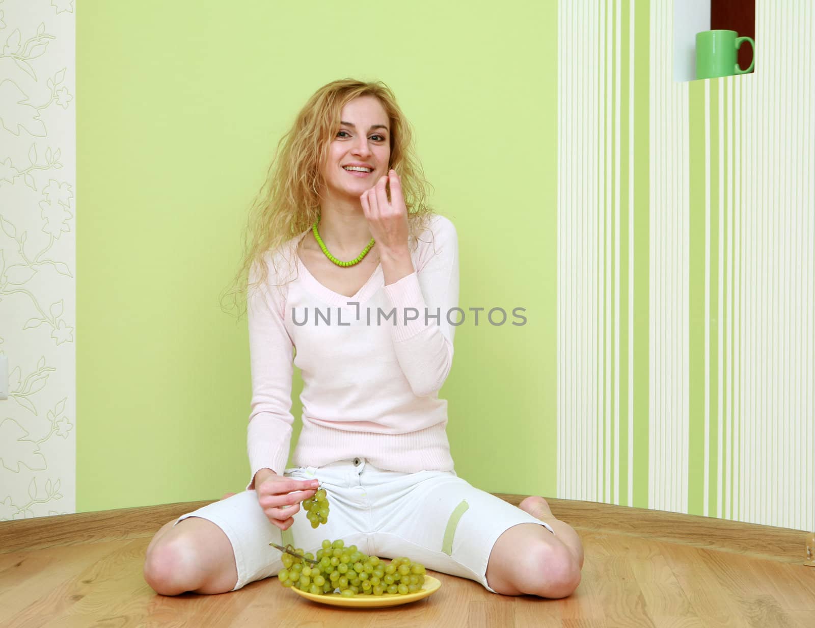 An image of a girl with a bunch of green grapes on plate