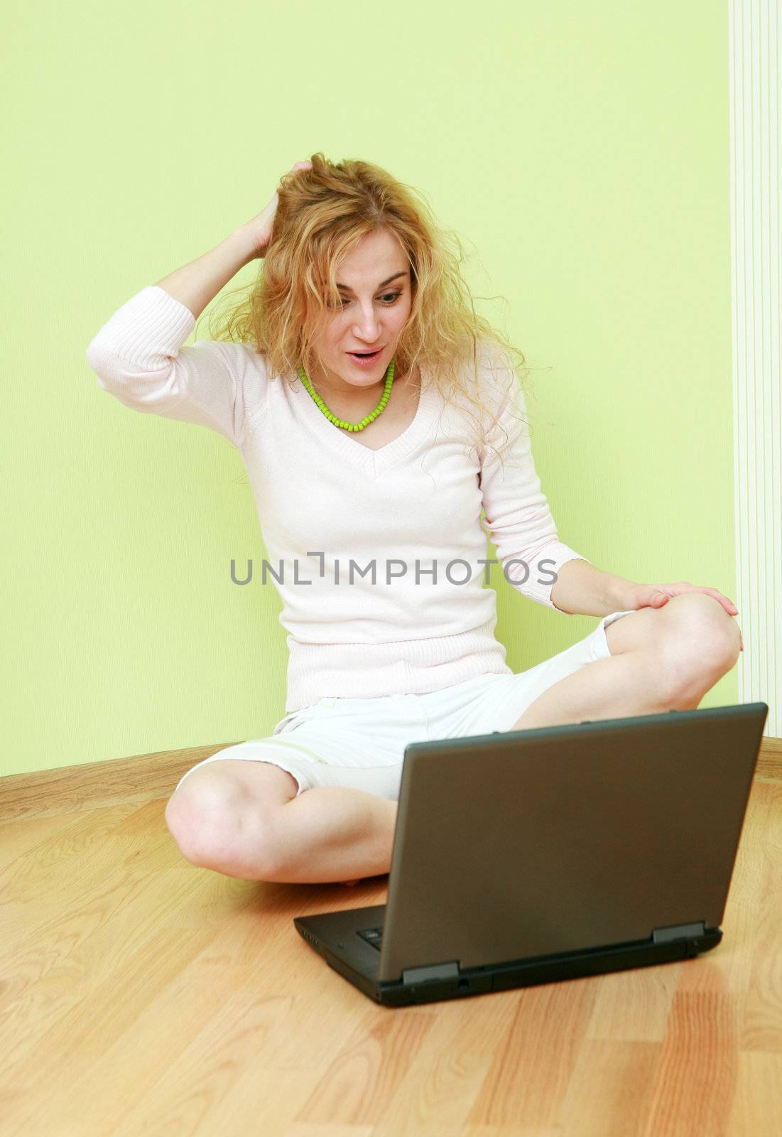 An image of a girl with a laptop on floor